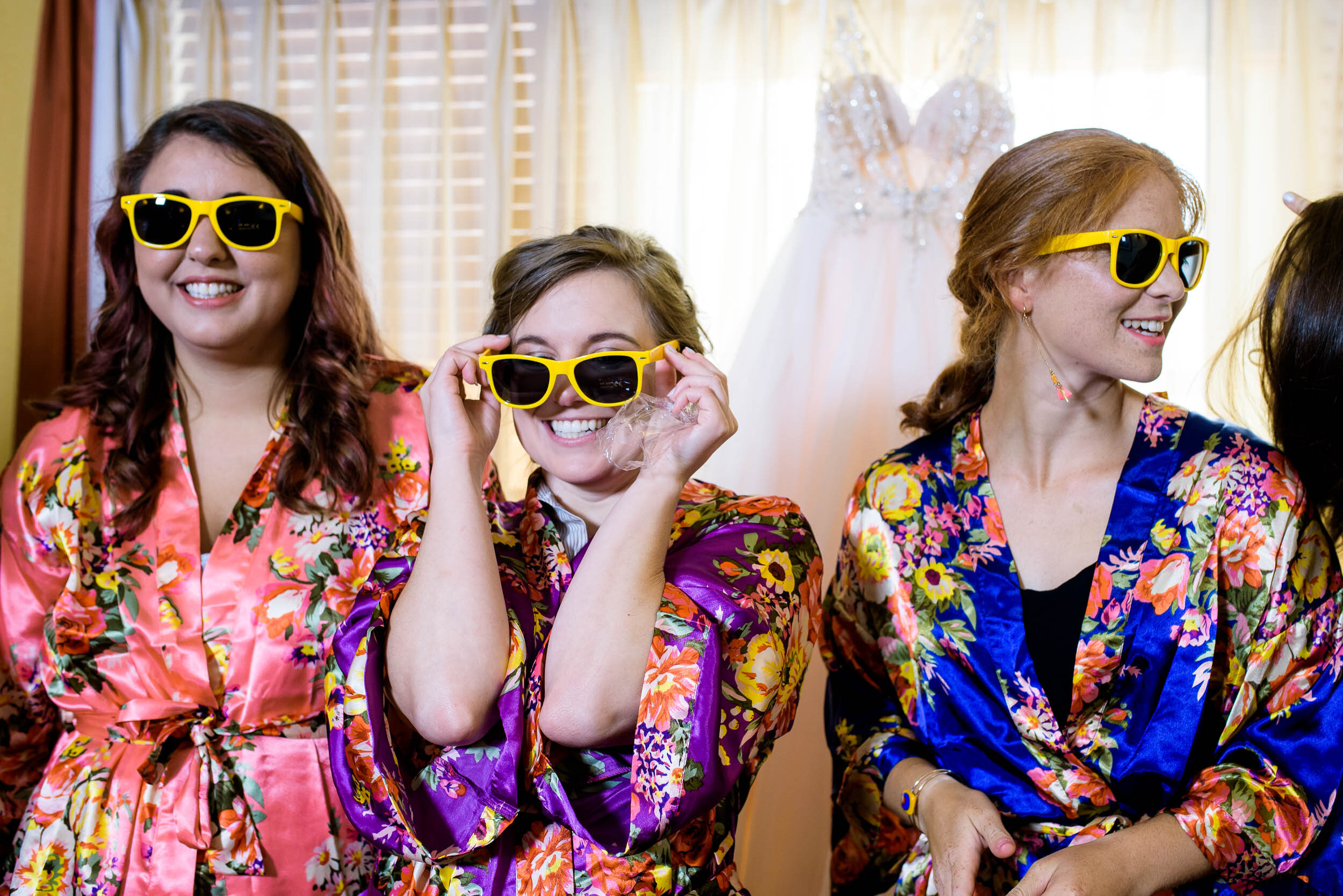 Bridesmaids having fun with matching robes and sunglasses: Columbus Park Refectory wedding captured by J. Brown Photography.