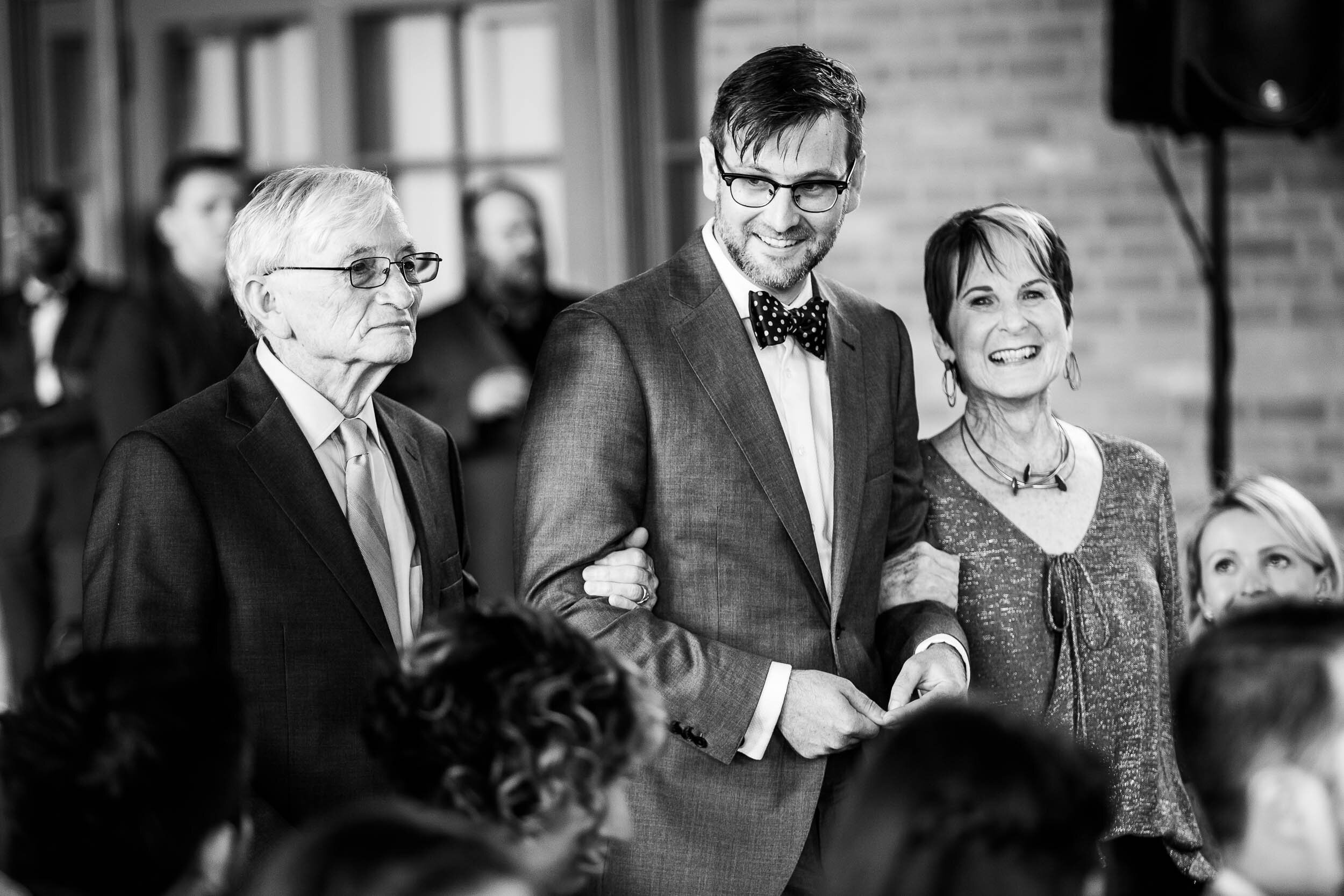 Groom walks down the aisle with his parents: Columbus Park Refectory Chicago wedding captured by J. Brown Photography.