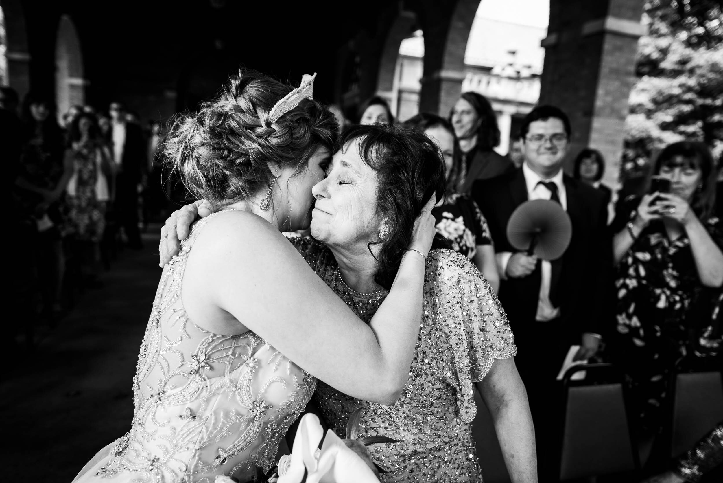 Bride and mom hug during her wedding ceremony: Columbus Park Refectory Chicago wedding captured by J. Brown Photography.