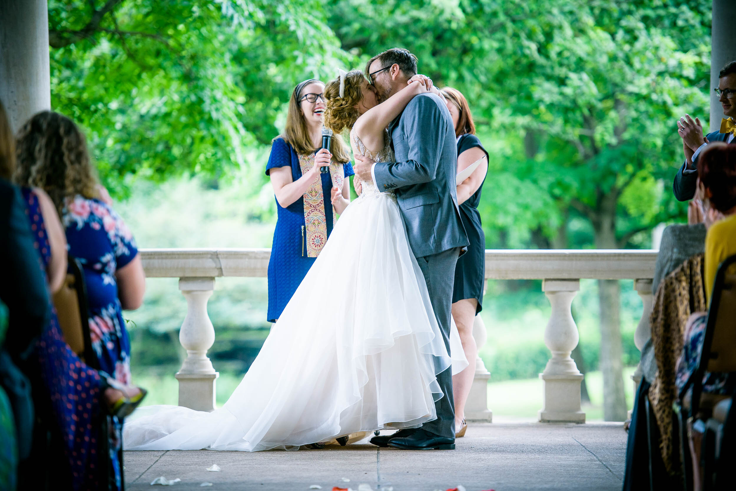 Bride and groom kiss during their ceremony: Columbus Park Refectory Chicago wedding captured by J. Brown Photography.