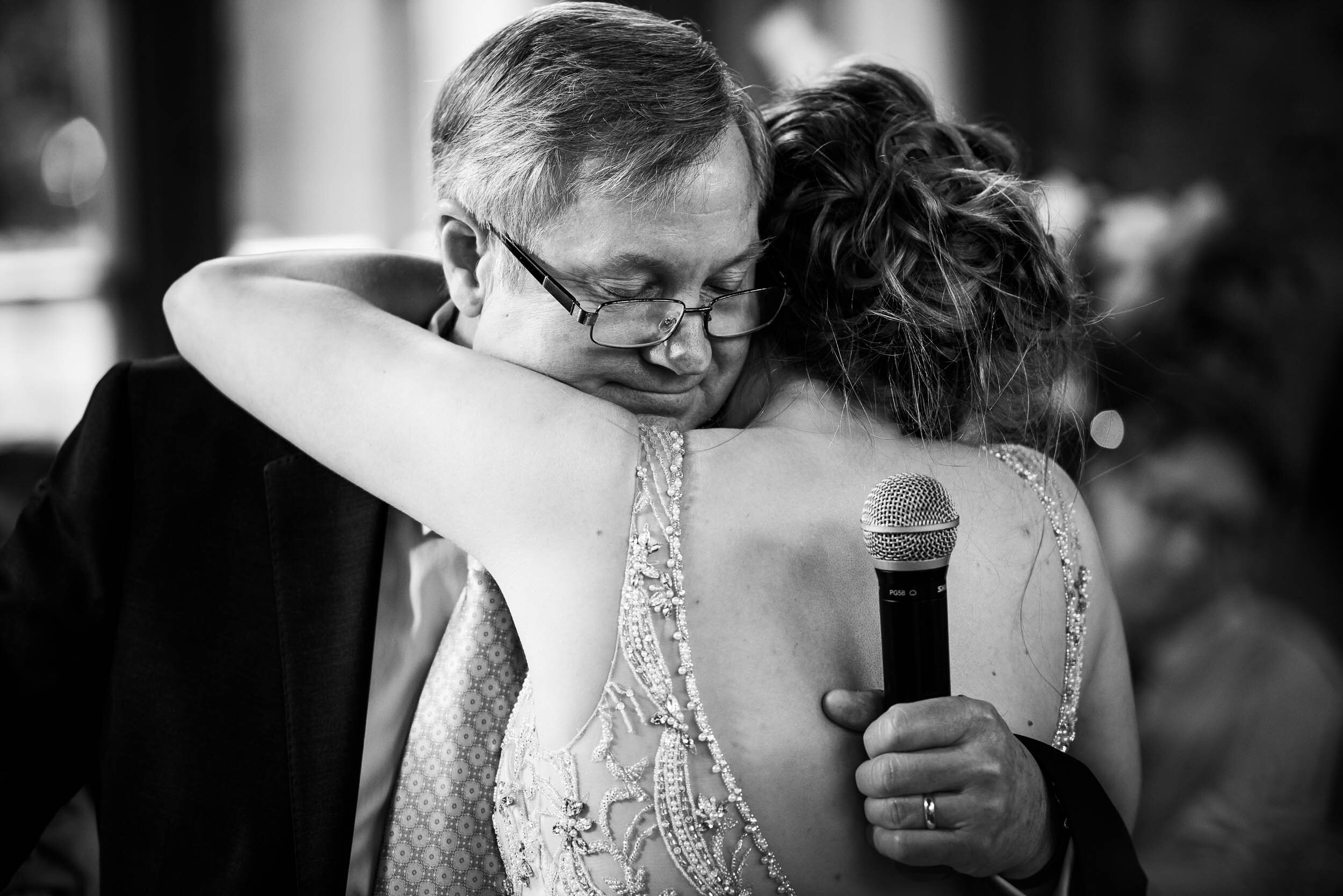 Father and bride hug after his wedding toast: Columbus Park Refectory Chicago wedding captured by J. Brown Photography.
