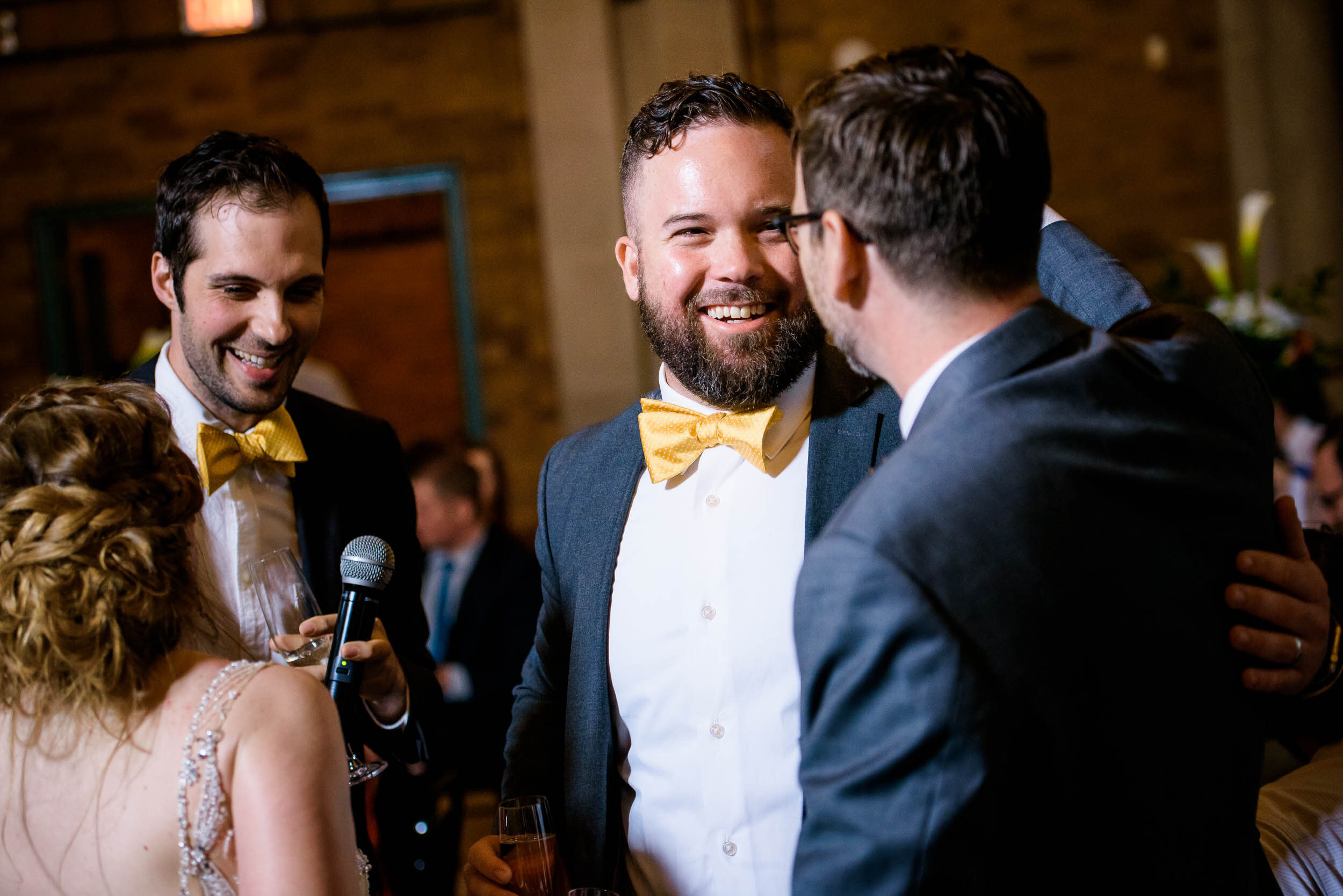 Groom hugs is best men after their toast: Columbus Park Refectory Chicago wedding captured by J. Brown Photography.