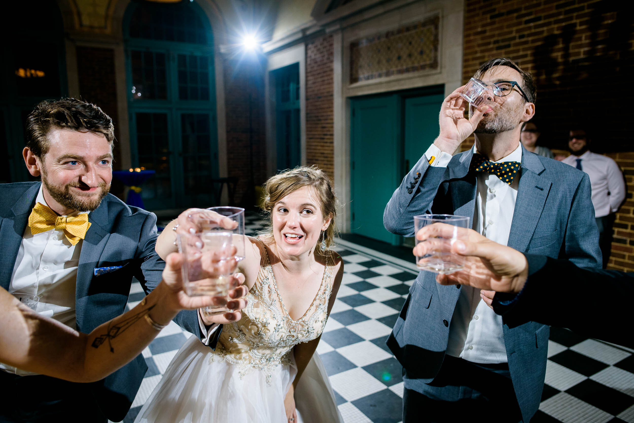 Wedding party does a shot to kick off the reception: Columbus Park Refectory Chicago wedding captured by J. Brown Photography.
