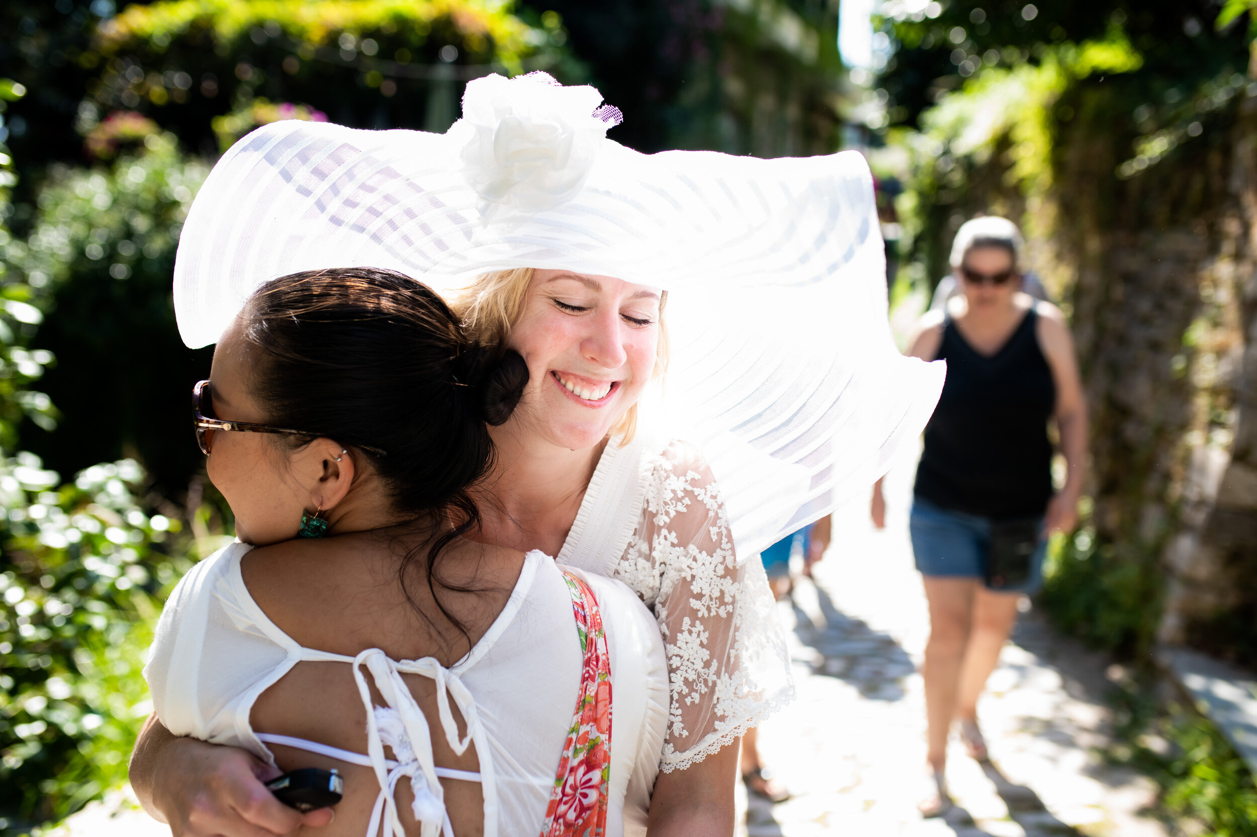 Bride hugs newly arriving guests:  photo of destination wedding in Greece by J. Brown Photography.