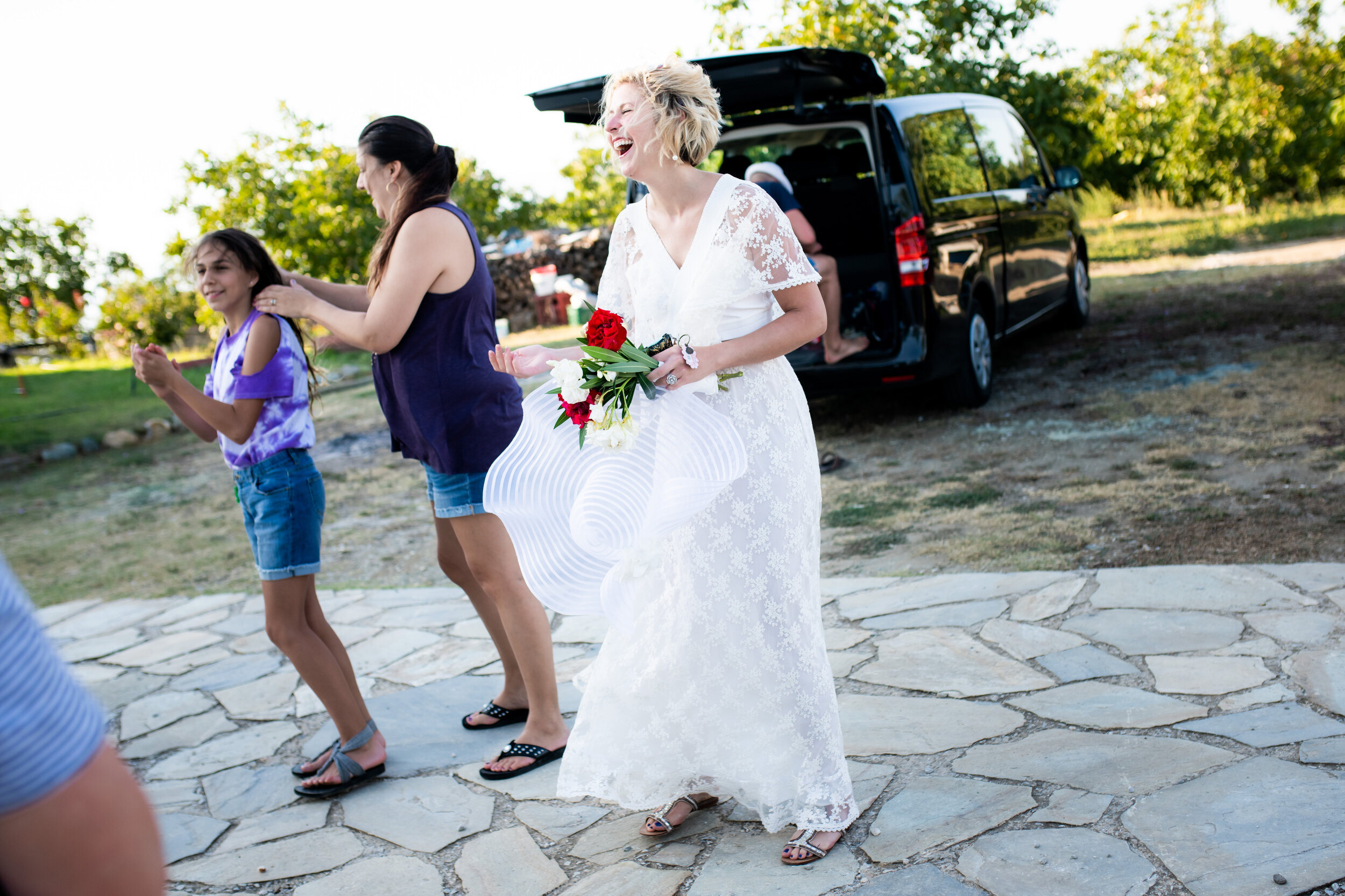 Bride with arriving guests at Patistis Vineyards in Greece:  photo of destination wedding in Greece by J. Brown Photography.