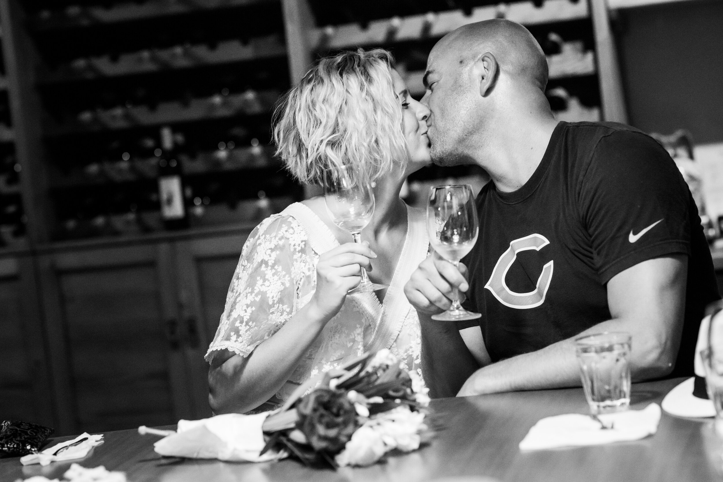 Bride and groom kiss during a wine tasting at Patistis Vineyards:  photo of destination wedding in Greece by J. Brown Photography.