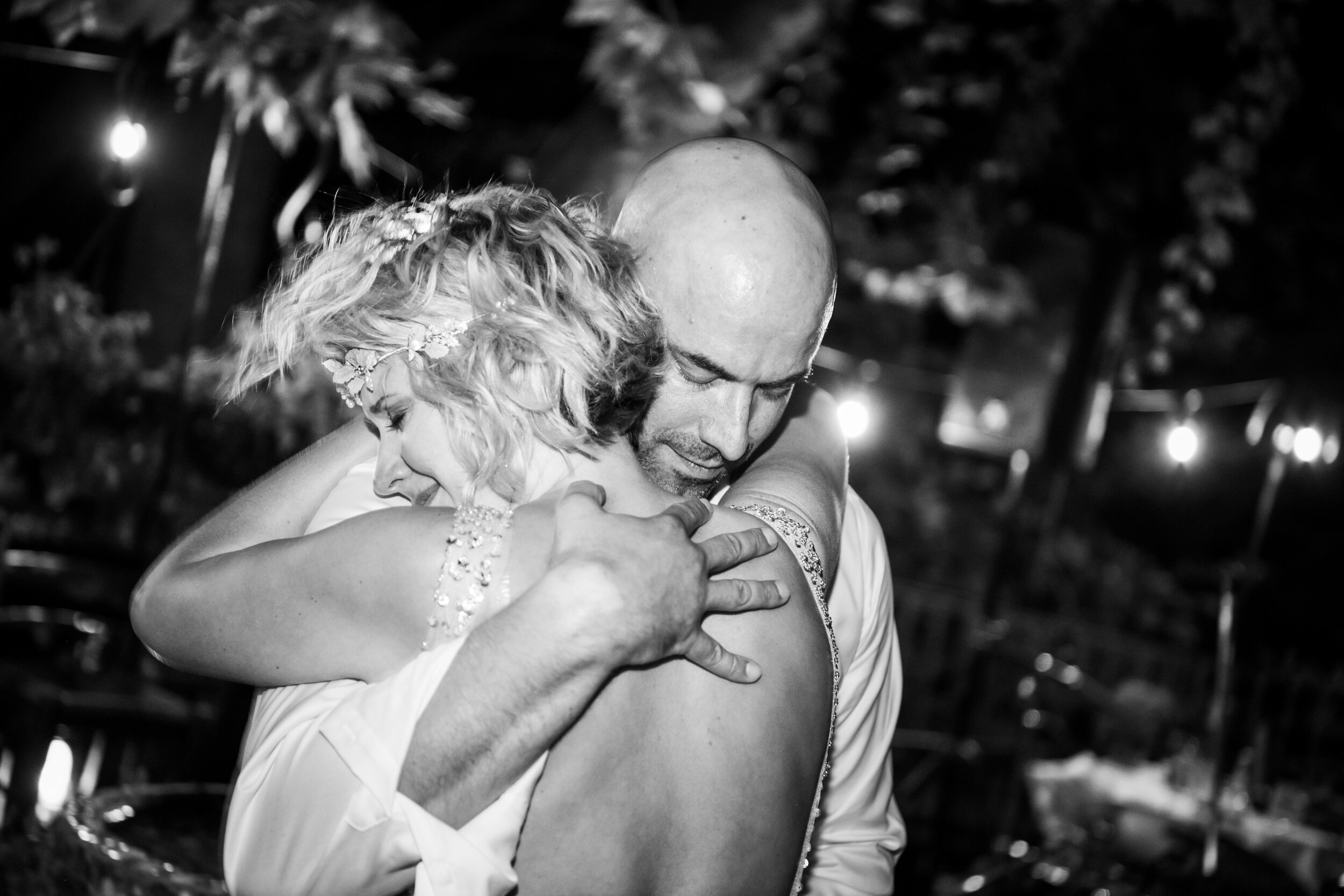 Bride and groom hug during their first dance:  destination wedding photo at the Lost Unicorn Hotel, Tsagarada, Greece by J. Brown Photography.