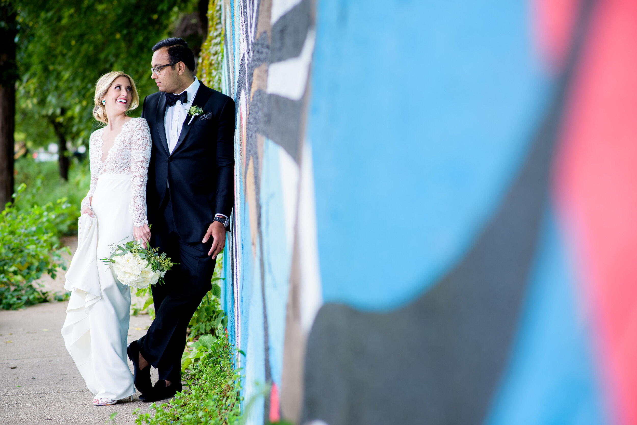 Portrait of bride and groom with street art in Pilsen: Geraghty Chicago wedding photography captured by J. Brown Photography.