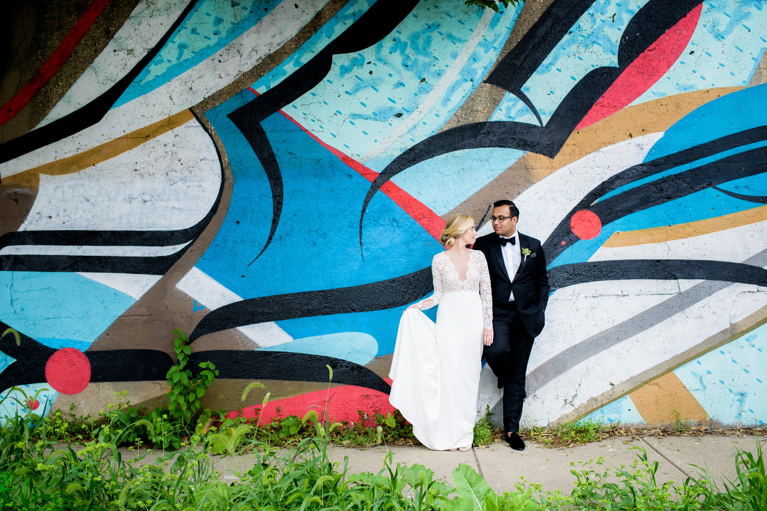 Creative wedding photo of bride and groom with street art mural in Pilsen: Geraghty Chicago wedding photography captured by J. Brown Photography.