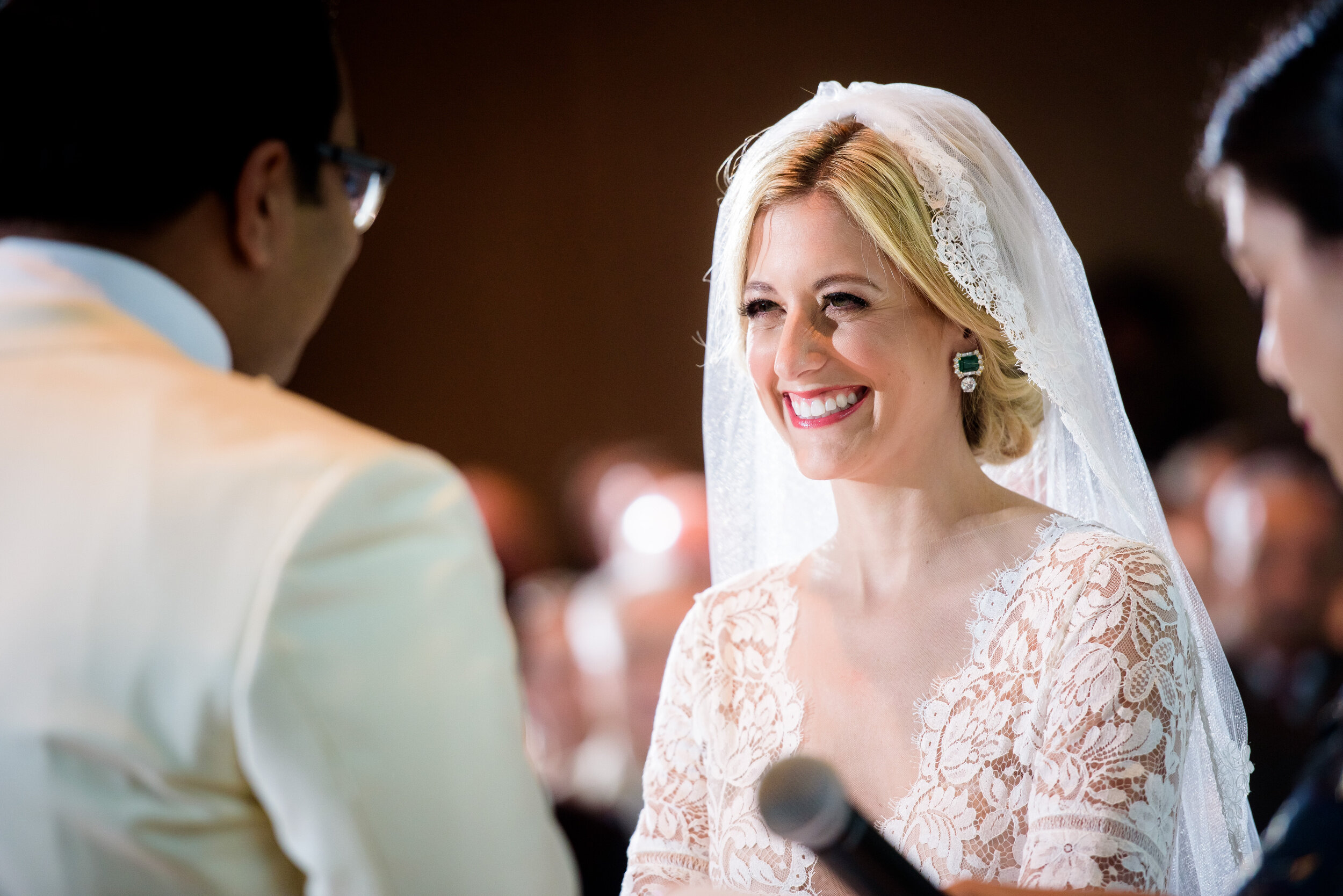 Bride smiles during her wedding ceremony: Geraghty Chicago wedding photography captured by J. Brown Photography.