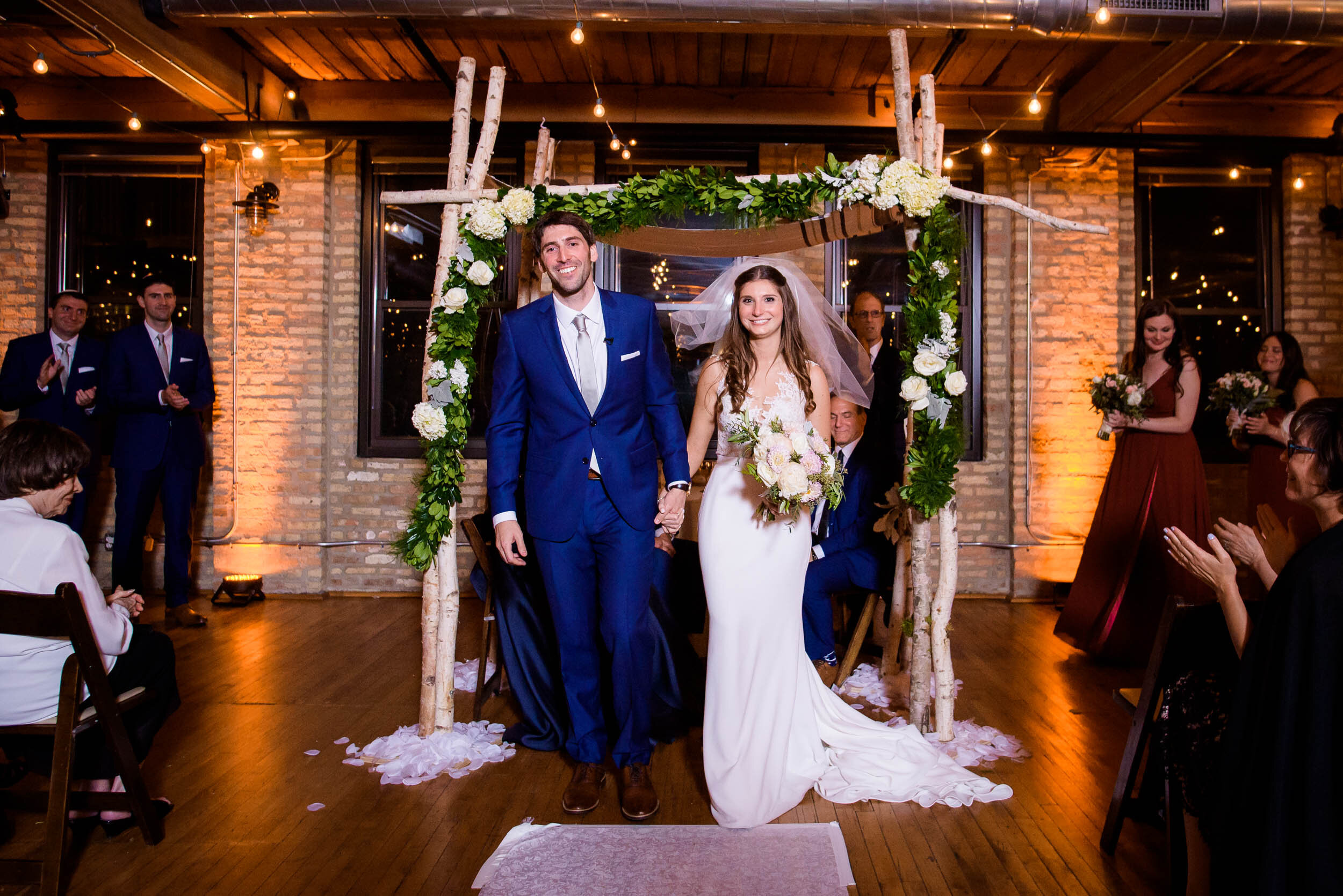 Bride and groom walk down the aisle married during their ceremony: Ravenswood Event Center Chicago wedding captured by J. Brown Photography.  