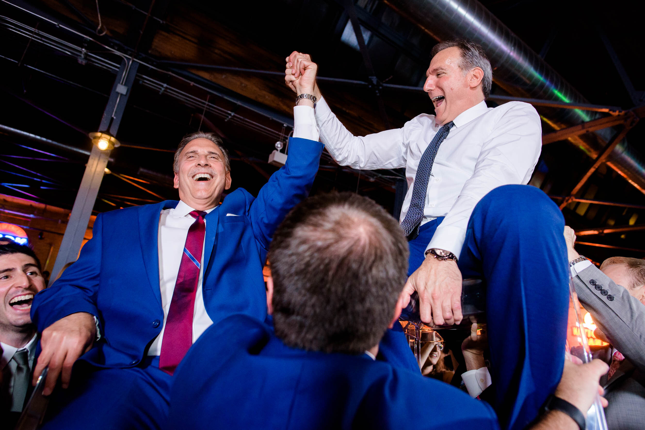 The dads are lifted during the horah: Ravenswood Event Center Chicago wedding captured by J. Brown Photography.  