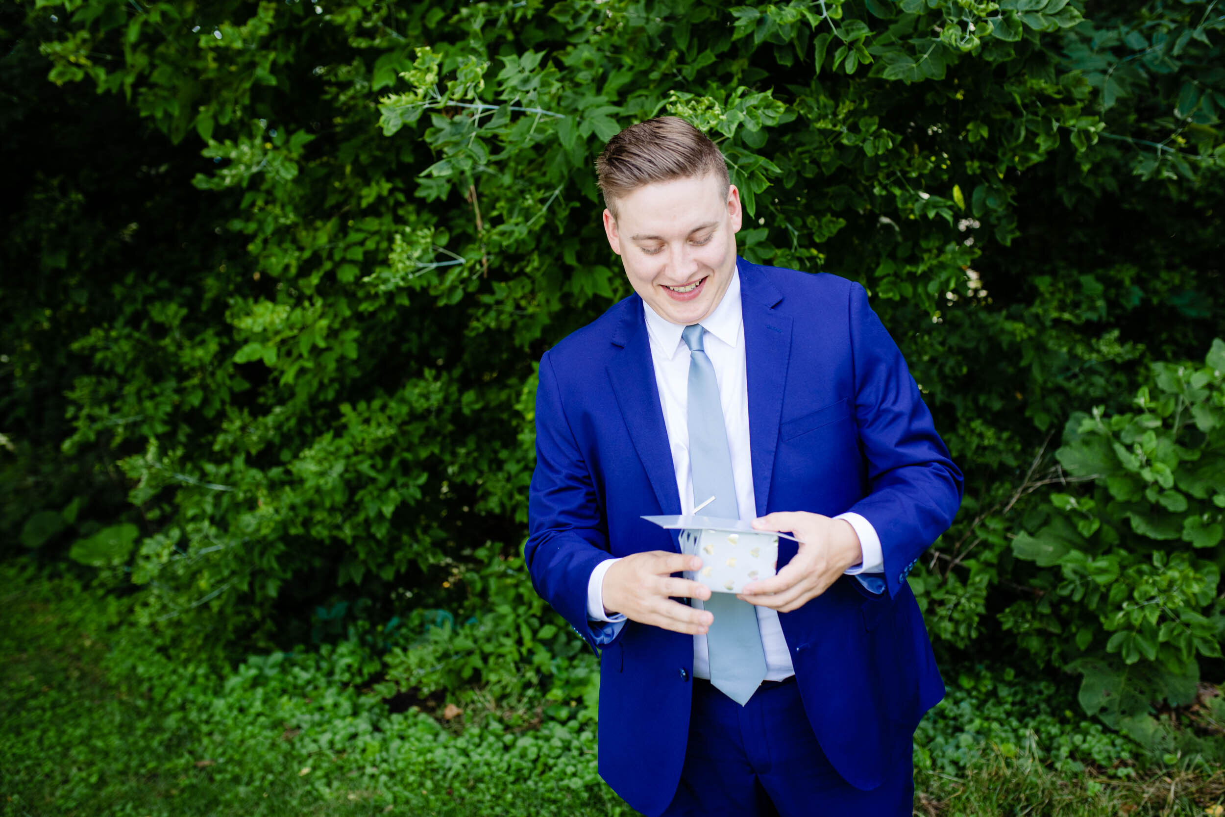 Groom opening his wedding gift:  Chicago backyard wedding photographed by J. Brown Photography.