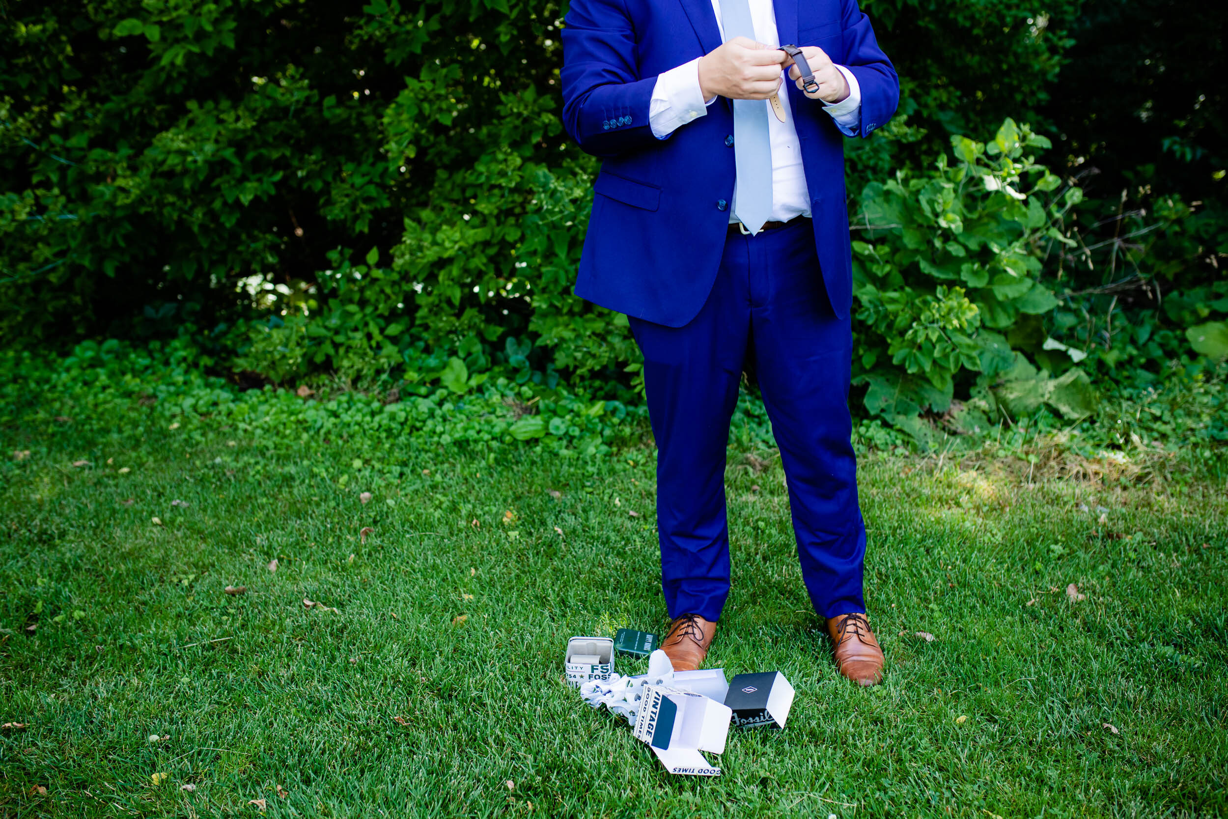 Groom opening his wedding gift from the bride:  Chicago backyard wedding photographed by J. Brown Photography.