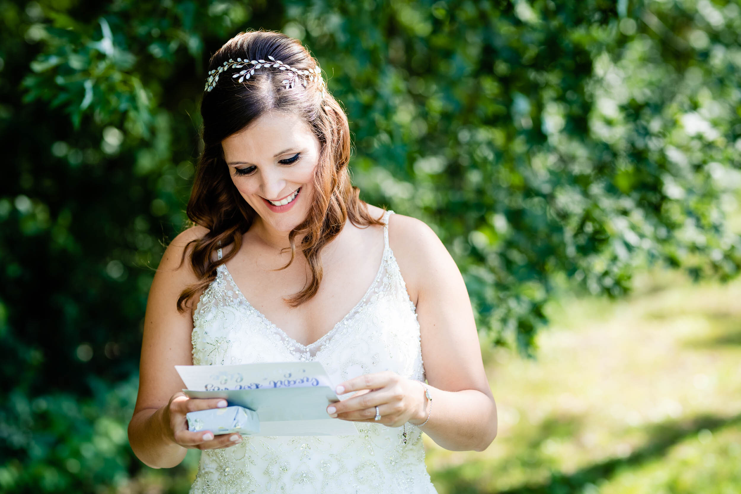Bride opening her gift from the groom:  Chicago backyard wedding photographed by J. Brown Photography.