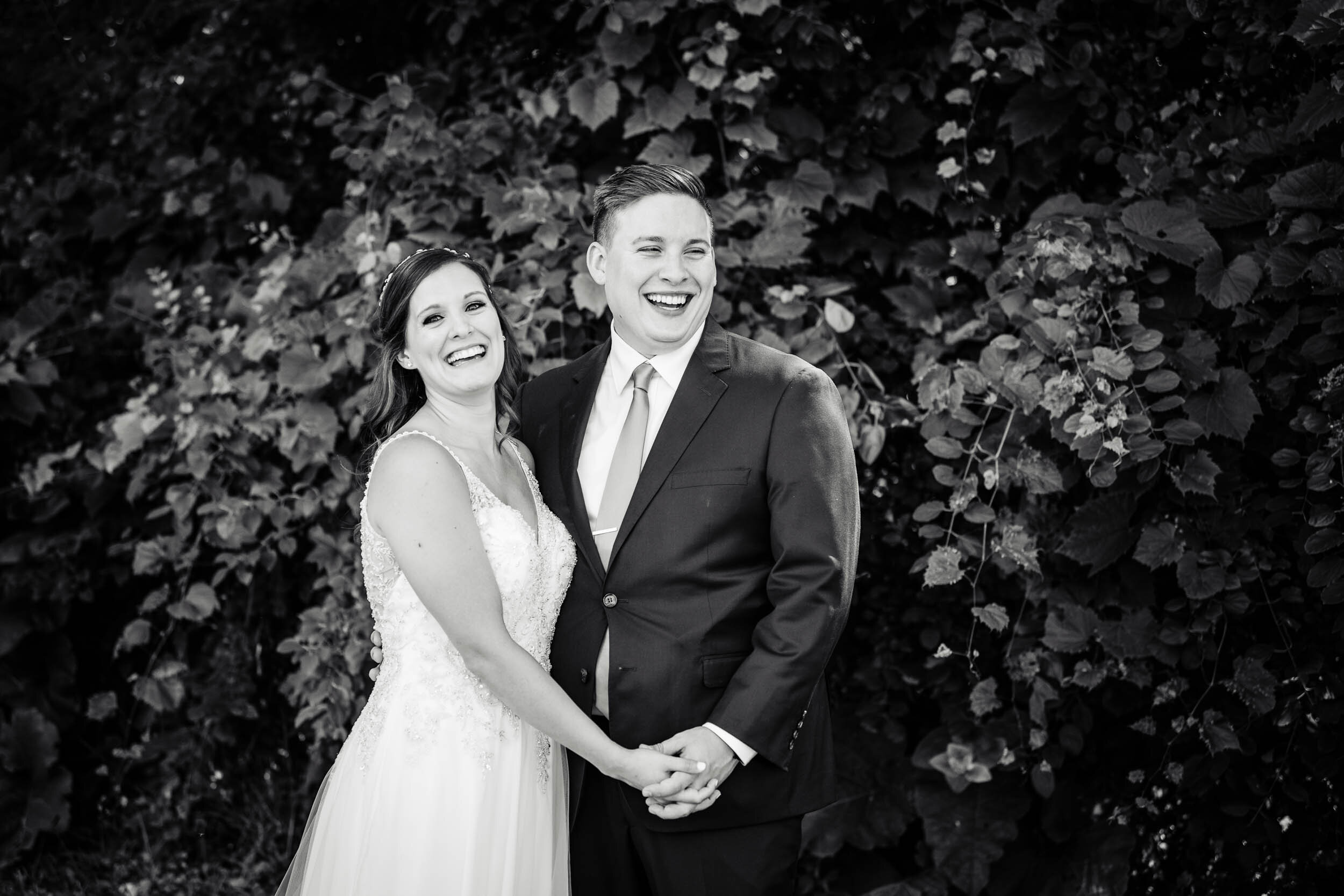 Bride and groom share a laugh during portraits: Chicago backyard wedding photographed by J. Brown Photography.