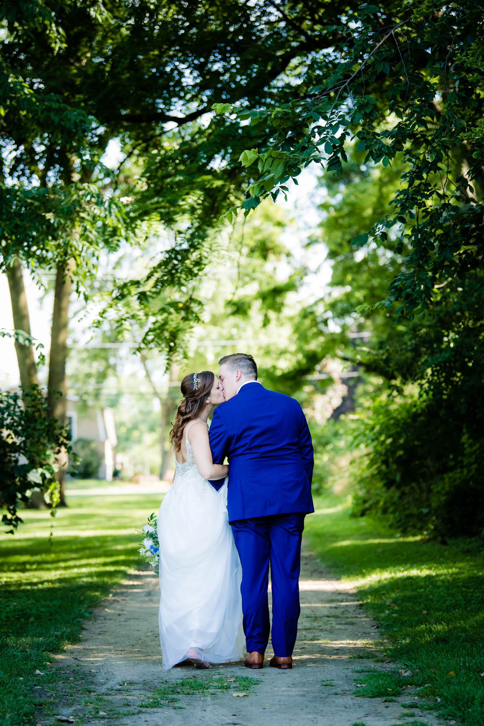 Bride and groom kiss for a wedding day portrait:  Chicago backyard wedding photographed by J. Brown Photography.