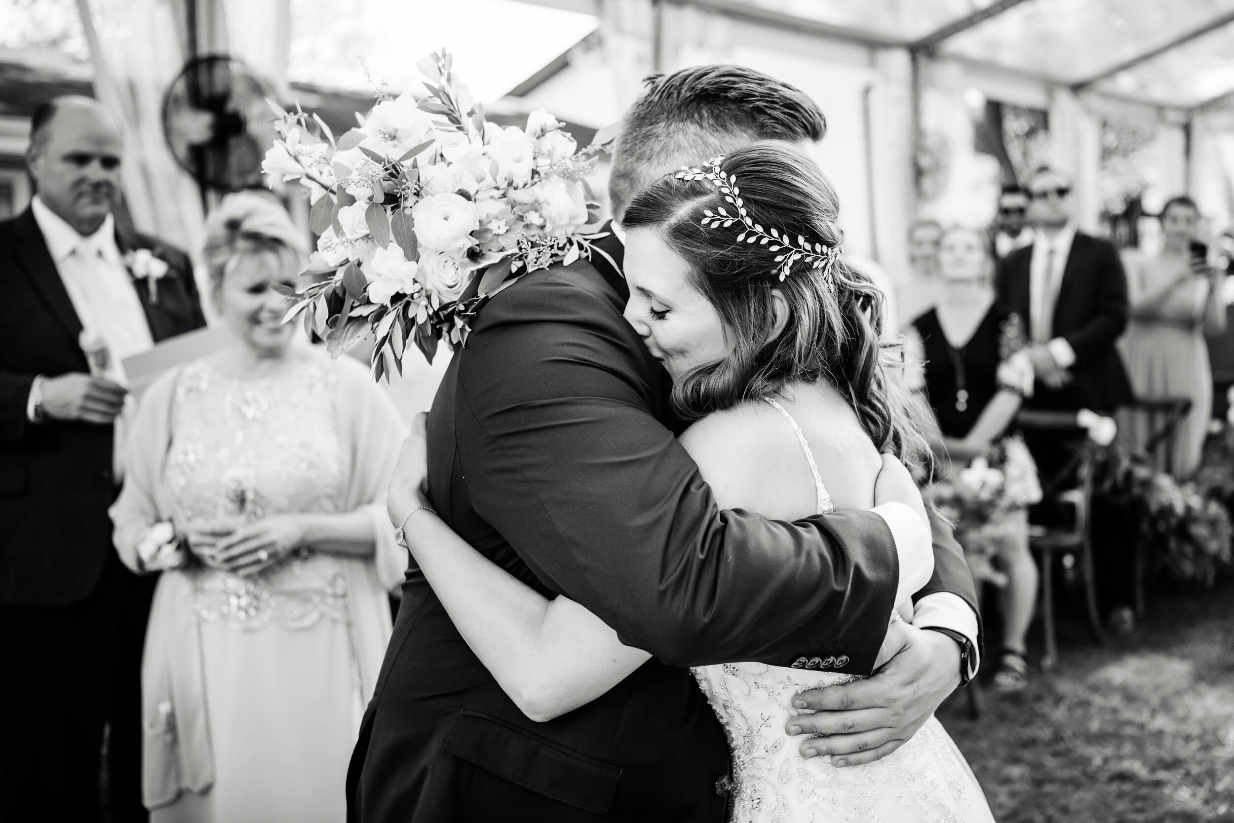 Bride and groom hug during their ceremony:  Chicago backyard wedding photographed by J. Brown Photography.