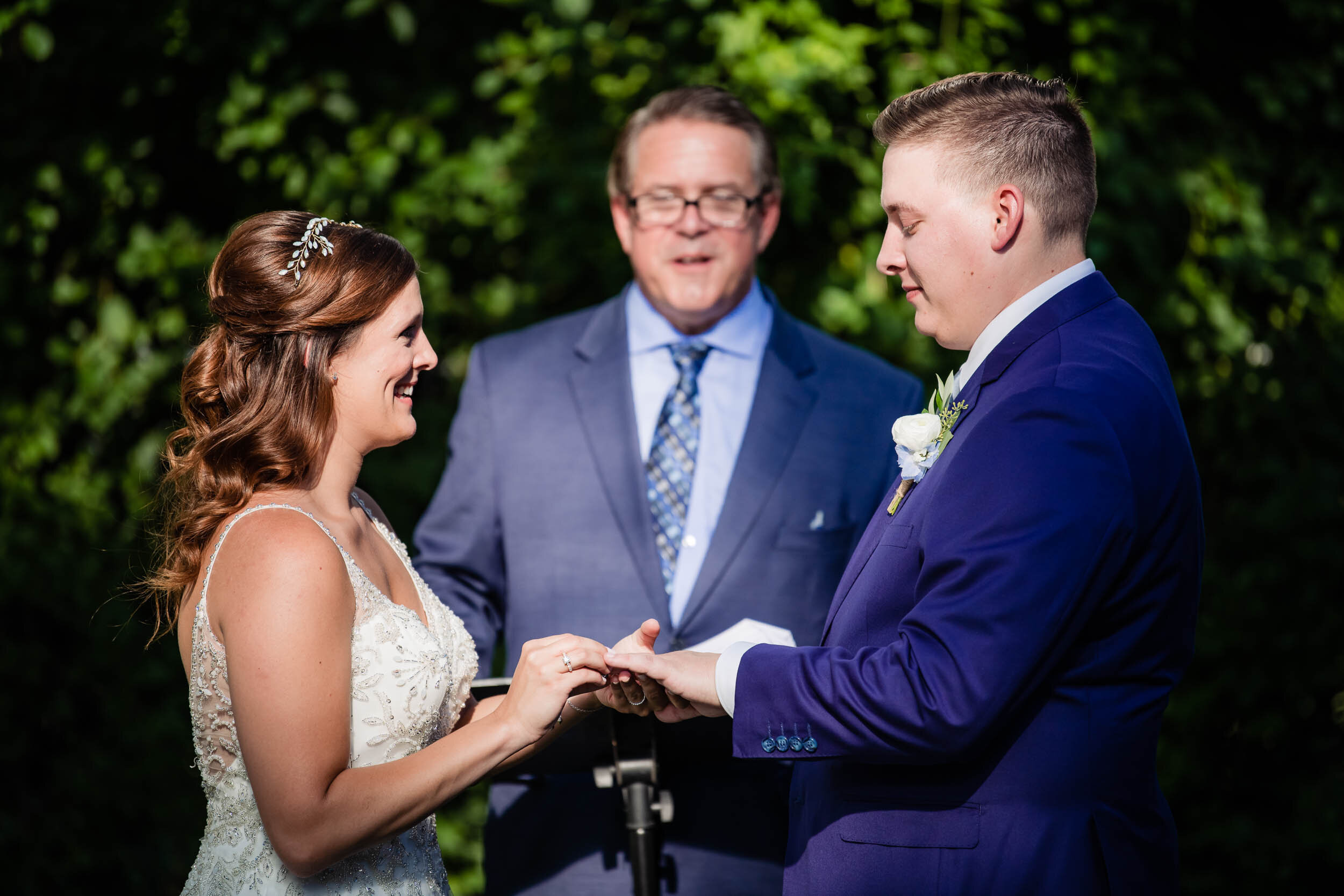 Bride and groom exchange ring during their ceremony:  Chicago backyard wedding photographed by J. Brown Photography.