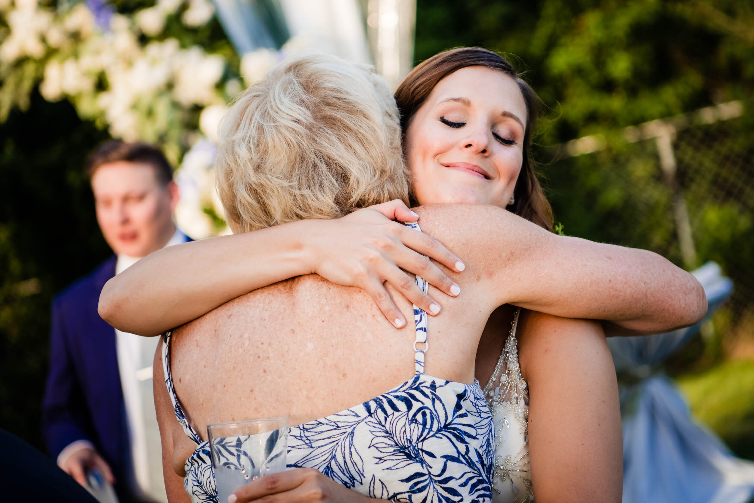 Bride hugs her family during her wedding:  Chicago backyard wedding photographed by J. Brown Photography.
