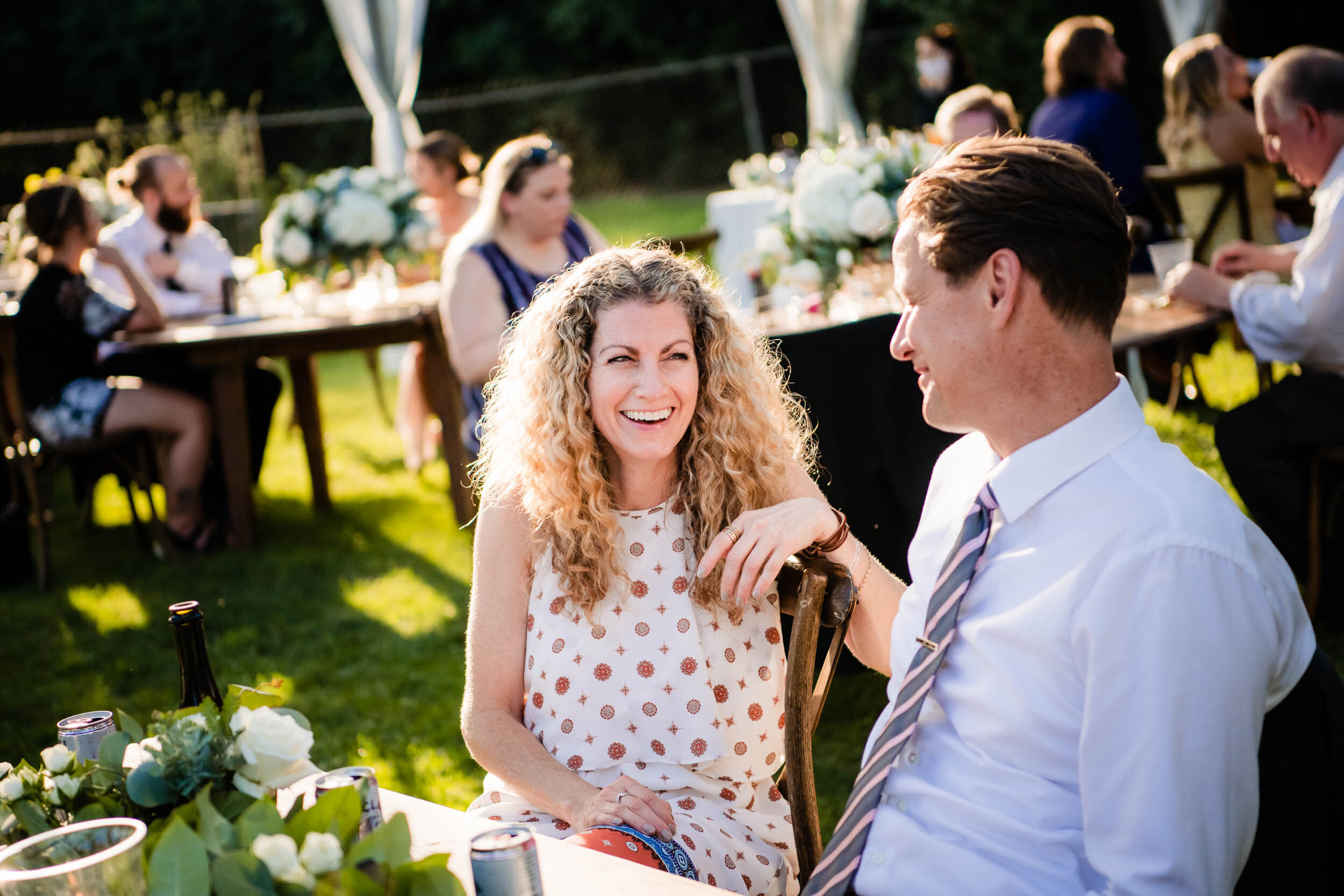 Guests laugh and talk during the reception:  Chicago backyard wedding photographed by J. Brown Photography.