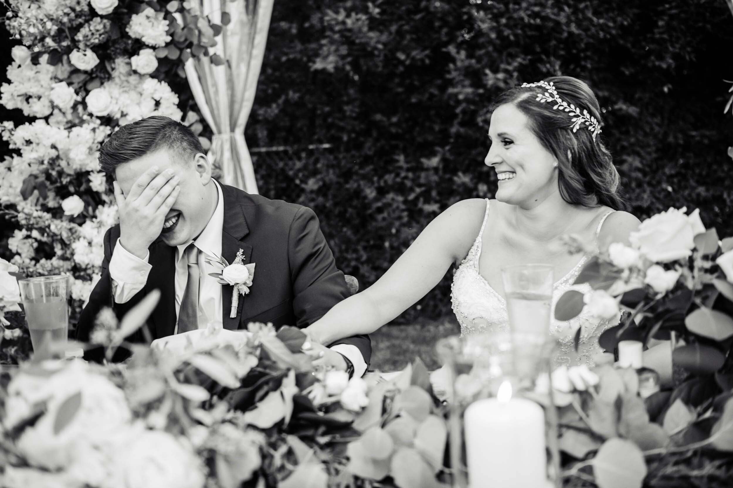 Bride and groom share a laugh during the best man toast:  Chicago backyard wedding photographed by J. Brown Photography.