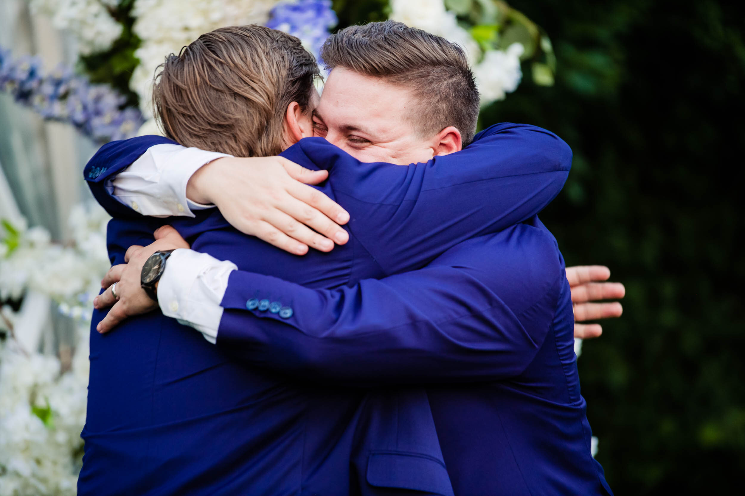 Groom and best man hug:  Chicago backyard wedding photographed by J. Brown Photography.