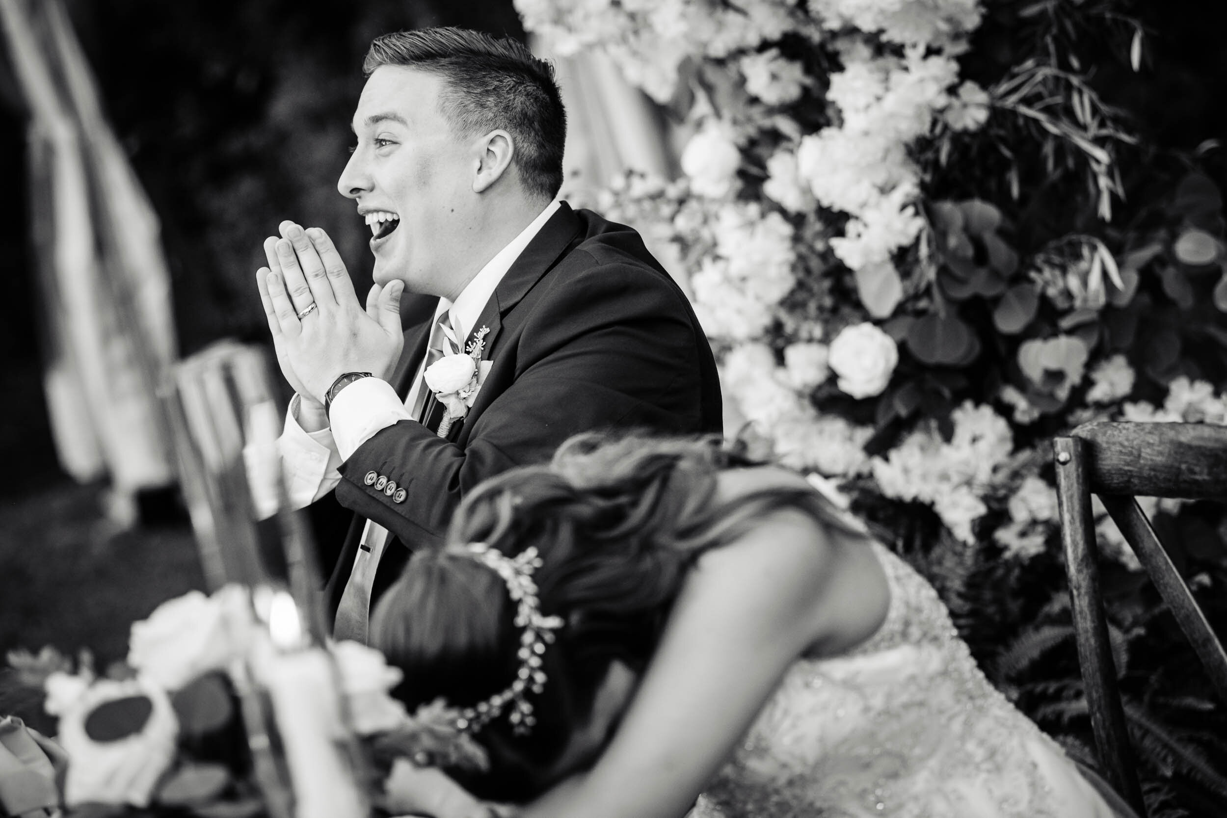 Bride and groom react during the maid of honor toast:  Chicago backyard wedding photographed by J. Brown Photography.