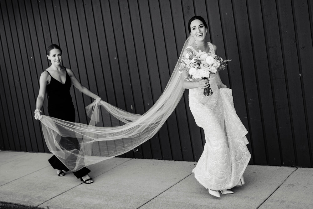 Bride laughs as she walk toward the first look at the Oakbrook Bath &amp; Tennis Club:  Chicago wedding photography by J. Brown Photography.