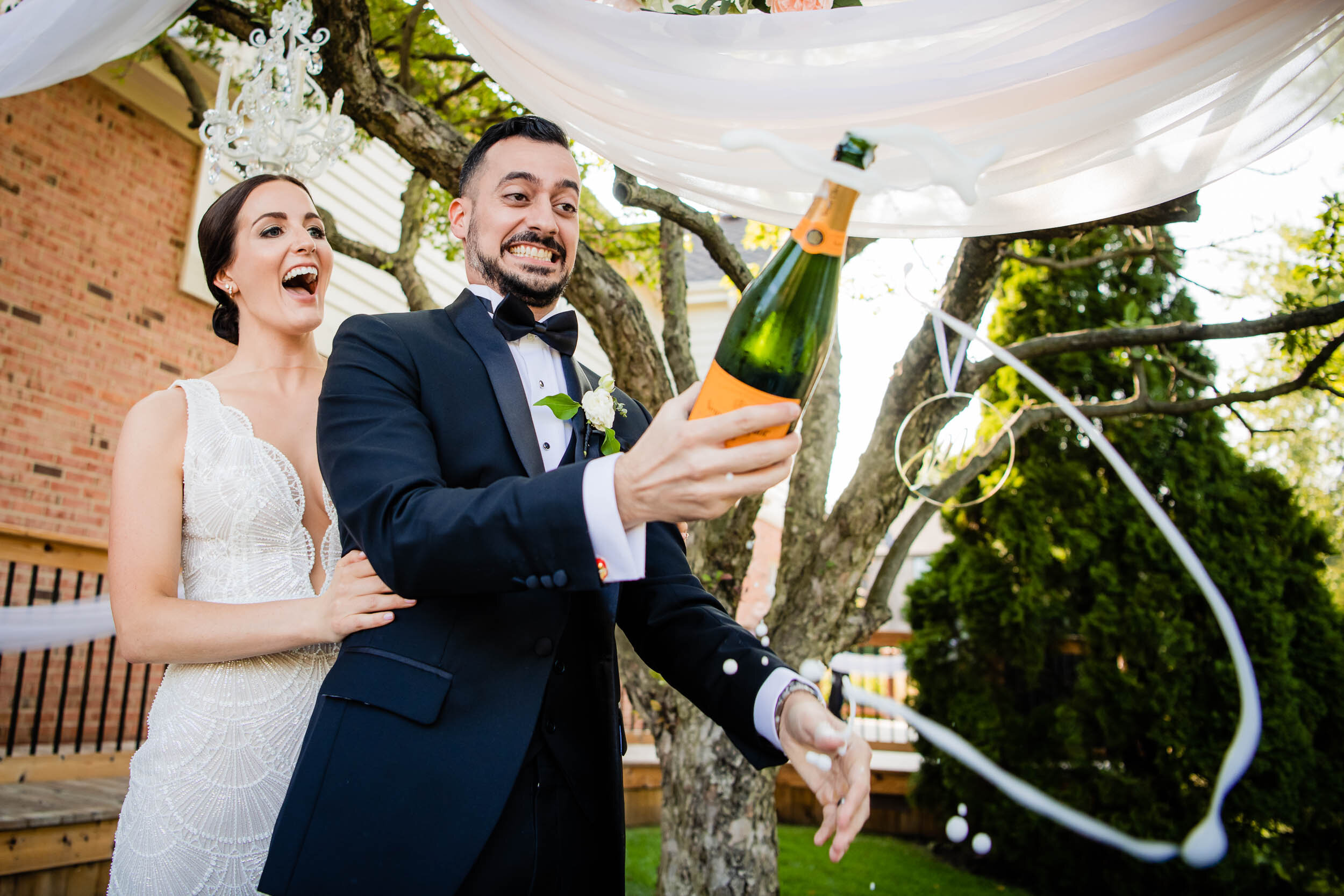 Bride and groom pop champagne after their wedding ceremony:  Chicago wedding photography by J. Brown Photography.
