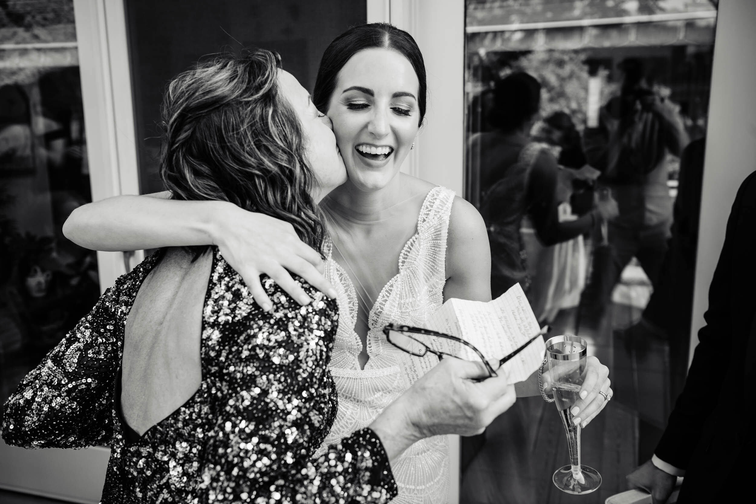 Bride and mother hug during a home wedding reception:  Chicago wedding photography by J. Brown Photography.