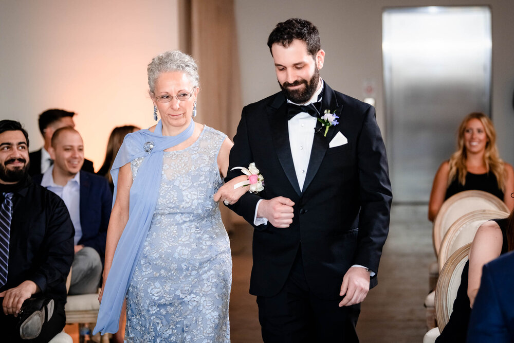 Groom and mom walk down the aisle during a ceremony at the Stockhouse:  Chicago wedding photographs by J. Brown Photography.