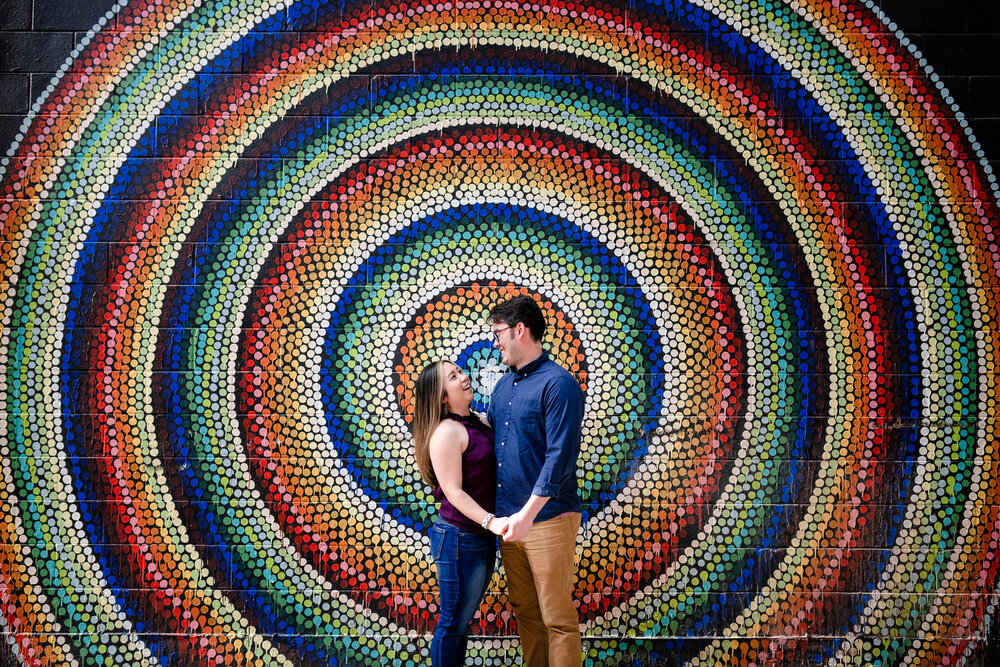 Best Engagement Photographers Near Me | Fulton Market Chicago | J. Brown Photography | photo of couple with concentric circle mural.  