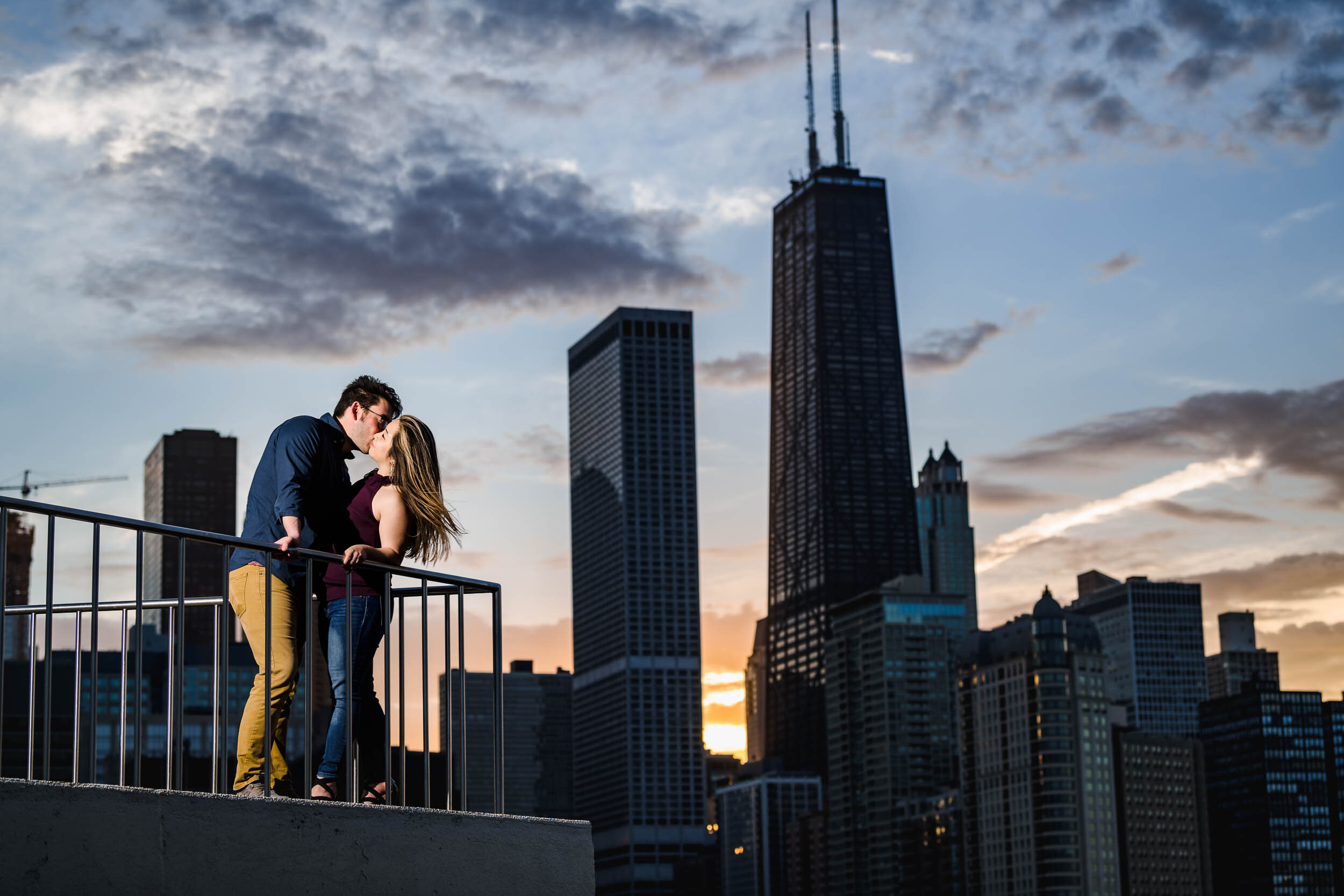 Best Engagement Photographers Near Me | Milton Lee Olive Park | J. Brown Photography | couple kisses at sunset with the Chicago skyline.