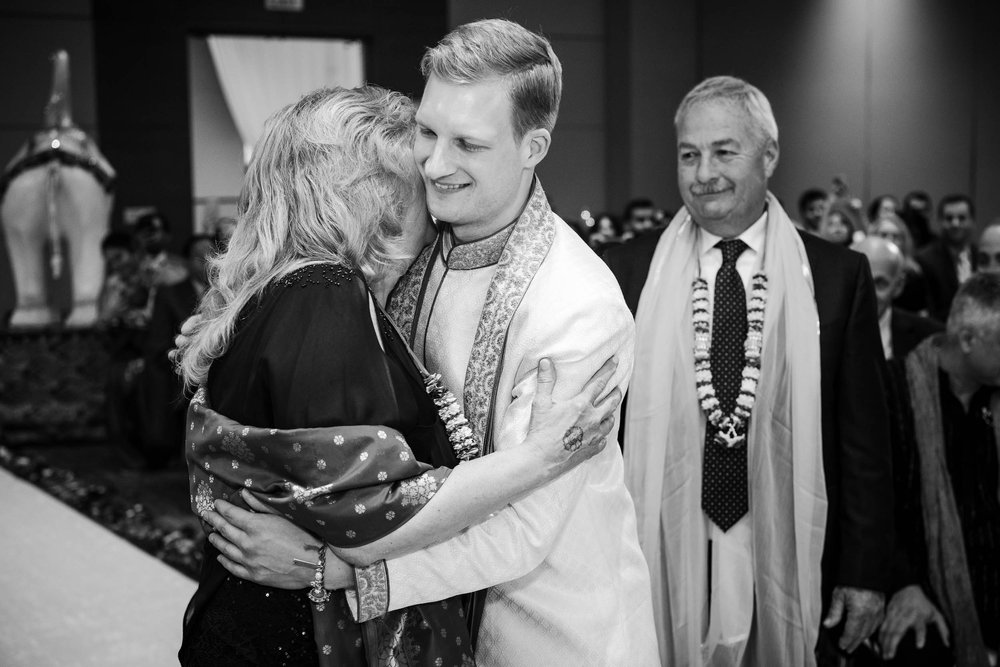 Indian Wedding Photographers | Renaissance Schaumburg | J. Brown Photography | groom hugs mom during wedding ceremony.