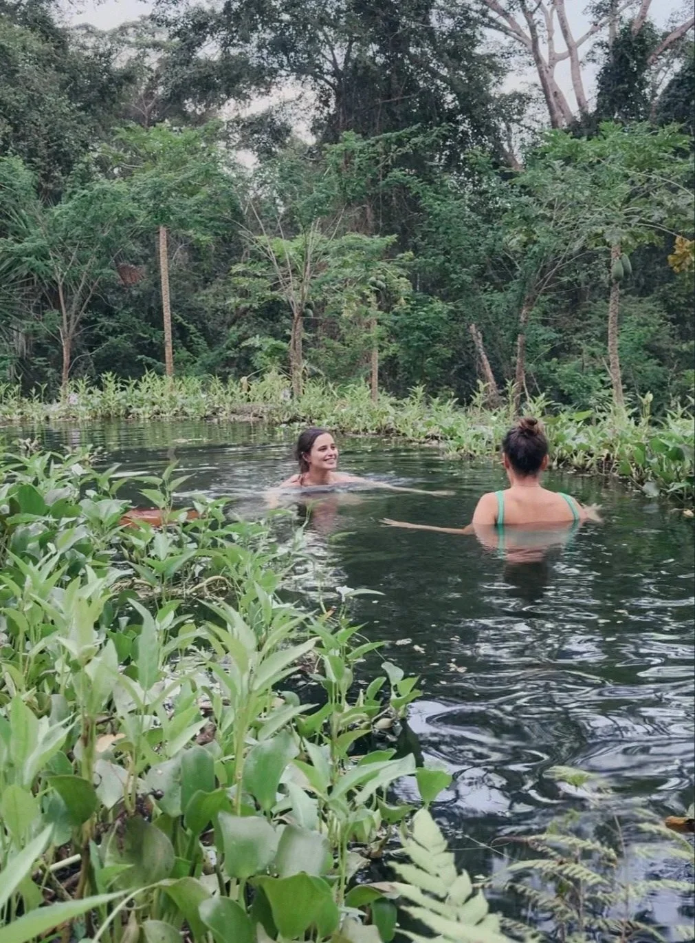Guests swimming in a natural freshwater pond during free time at a rainforest retreat near Puerto Viejo, Costa Rica
