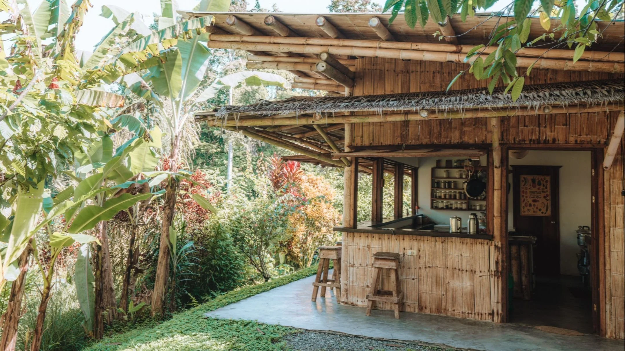 Off-grid bamboo homestead infrastructure with solar energy, rainwater collection, and outdoor kitchen systems in the tropics