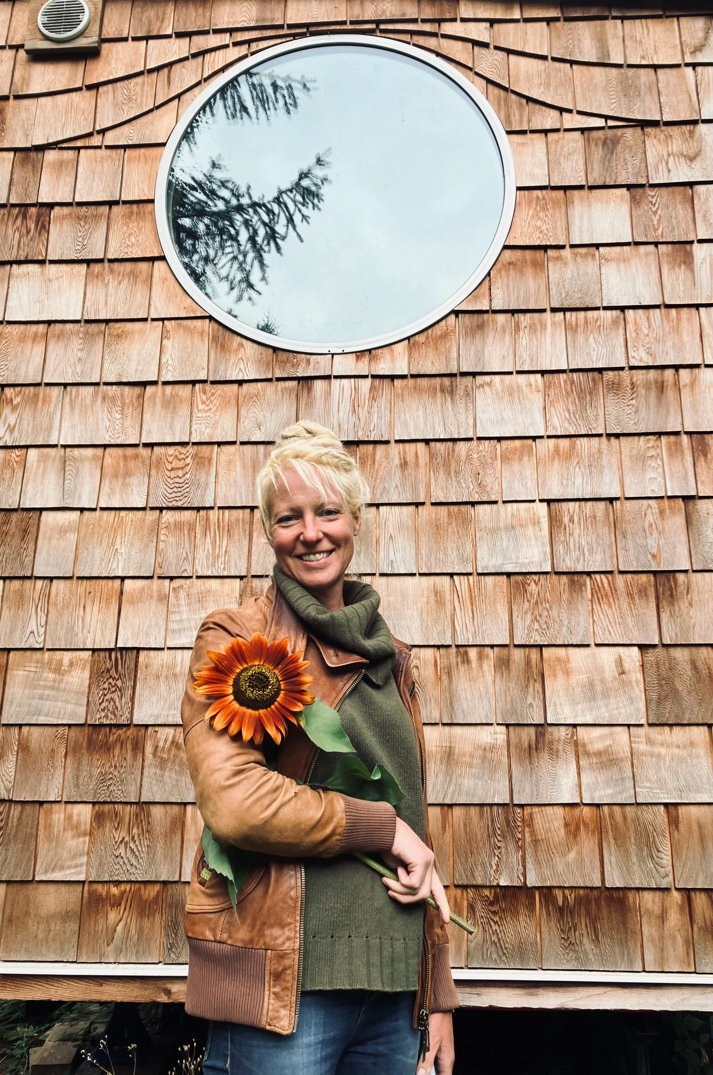 Tobi in front of cedar shake tiny house siding