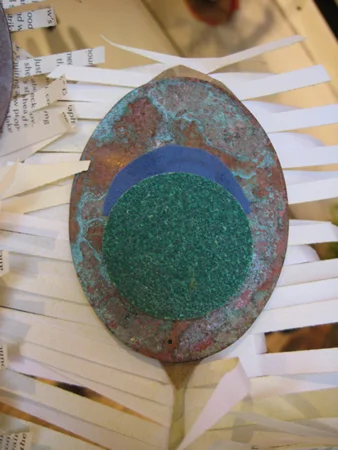 I found some weathered copper leaves left over from a previous display project and used them for part of the feathers; I love how the green patina adds a bit of subtle color and picks up on the colors of the fabric and sandpaper I used for the eyes of the feathers. 
