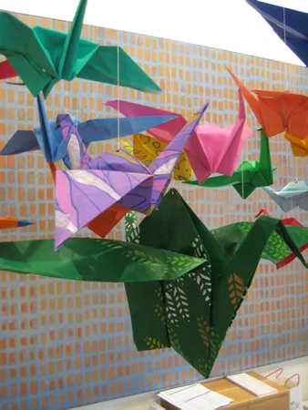 The smallest cranes were made from traditional origami paper. I was able to purchase nicely colored and printed paper up to 1’ X 1’, but to get the colors and prints I wanted for the larger cranes I had to paint the paper myself. The largest crane in the middle was made from a 4’ x 4’ sheet of paper that I painted and stenciled. All the other cranes in this shot were hand painted as well. 