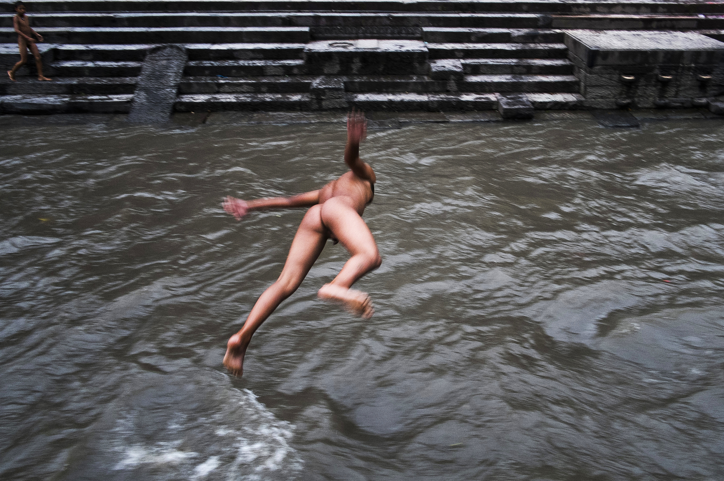 An orphan boy dives into the Bagmati River. 
