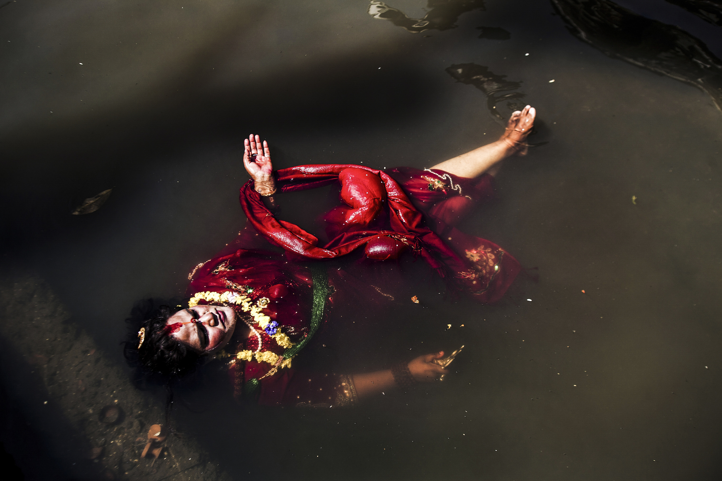 A sadvhi (female sadhu) performs for a crowd at the eastern entrance to Pashupatinath where purification rituals take place. 