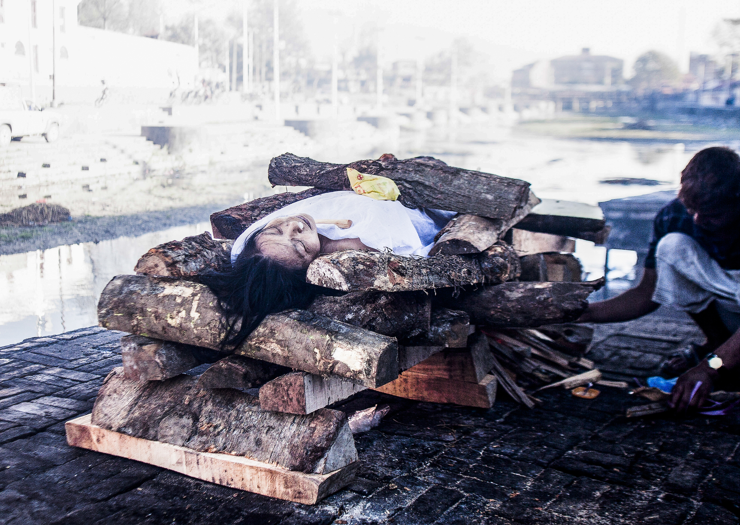 Death is believed to be contagious. For this reason Doms (a subcaste of the Untouchables) are the only caste allowed to touch dead bodies and perform cremations. Here a Dom prepares a wooden pyre for the cremation of a young woman at Pashupatinath's northern ghat. 