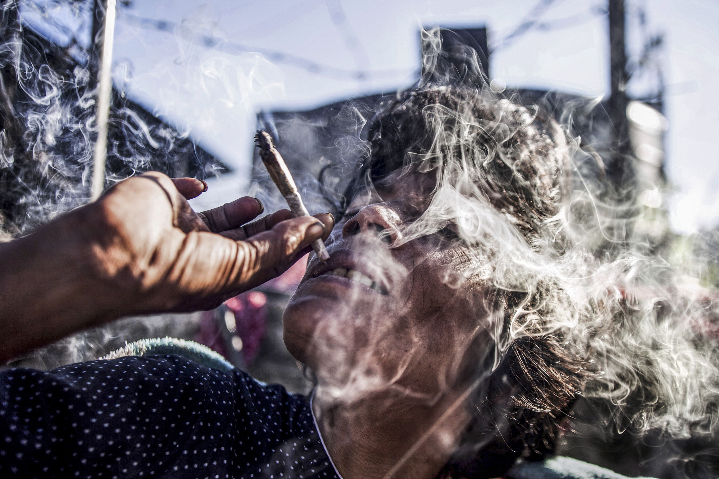 38-year-old Rupa smoking in her bed above Pashupatinath's northern cremation ghats. 