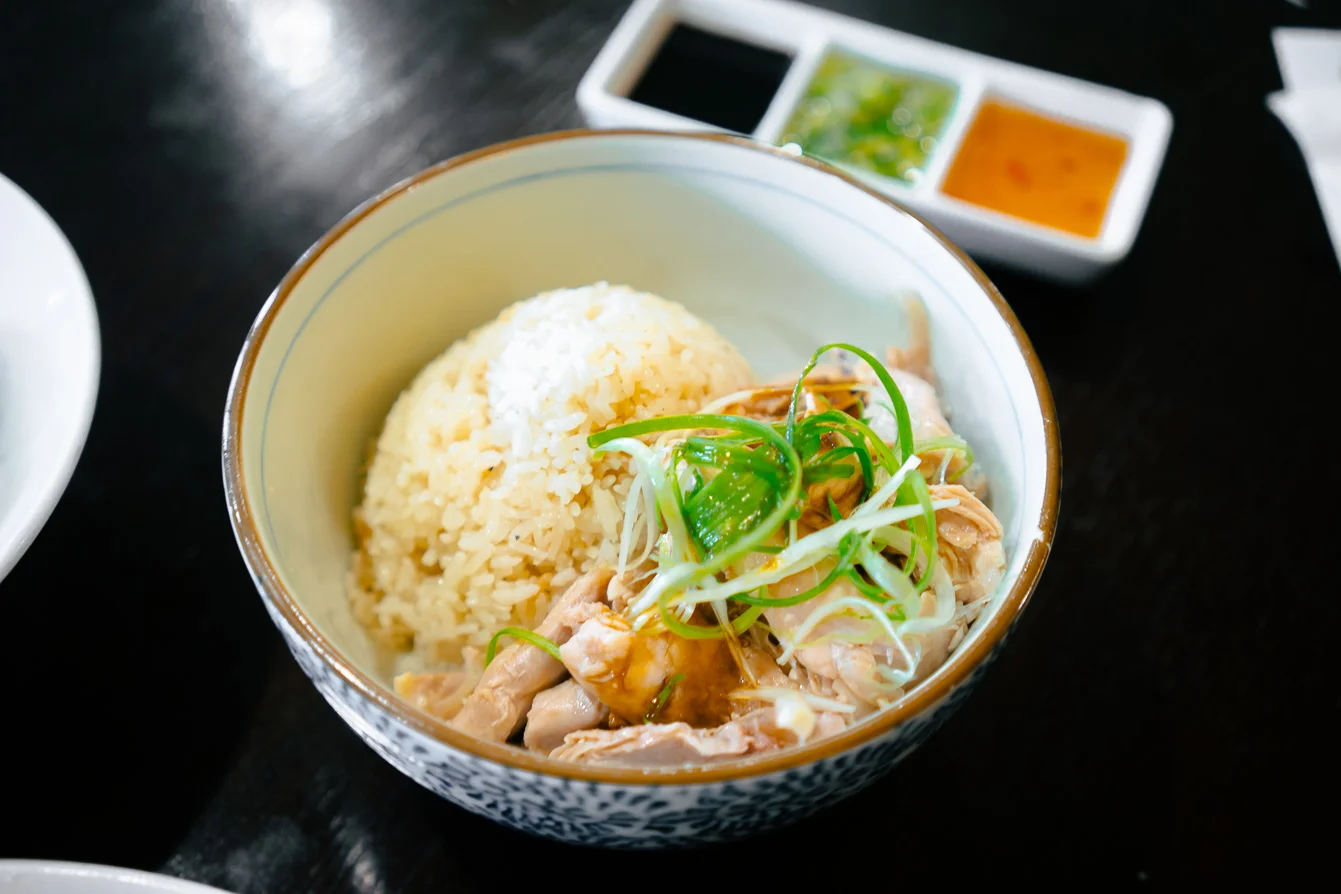 Organic Hainan Chicken Rice ( 有機海南雞飯) : Poached organic boneless, skinless chicken over lemongrass rice, served with ground ginger scallion paste, garlic chili sauce & sweet soy sauce on the side. Picture above is served "farmer's style."