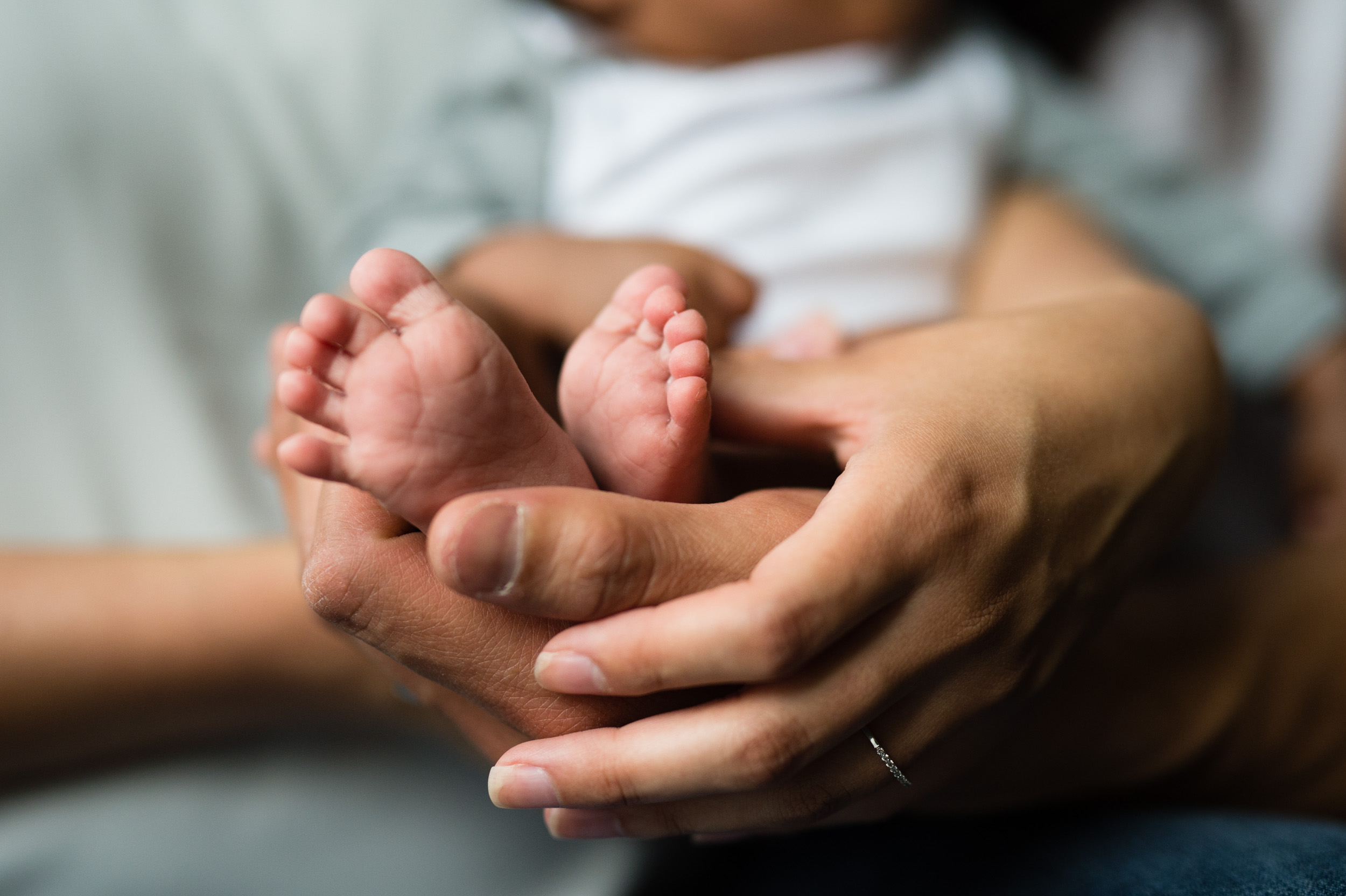 Newborn feet with parents hands