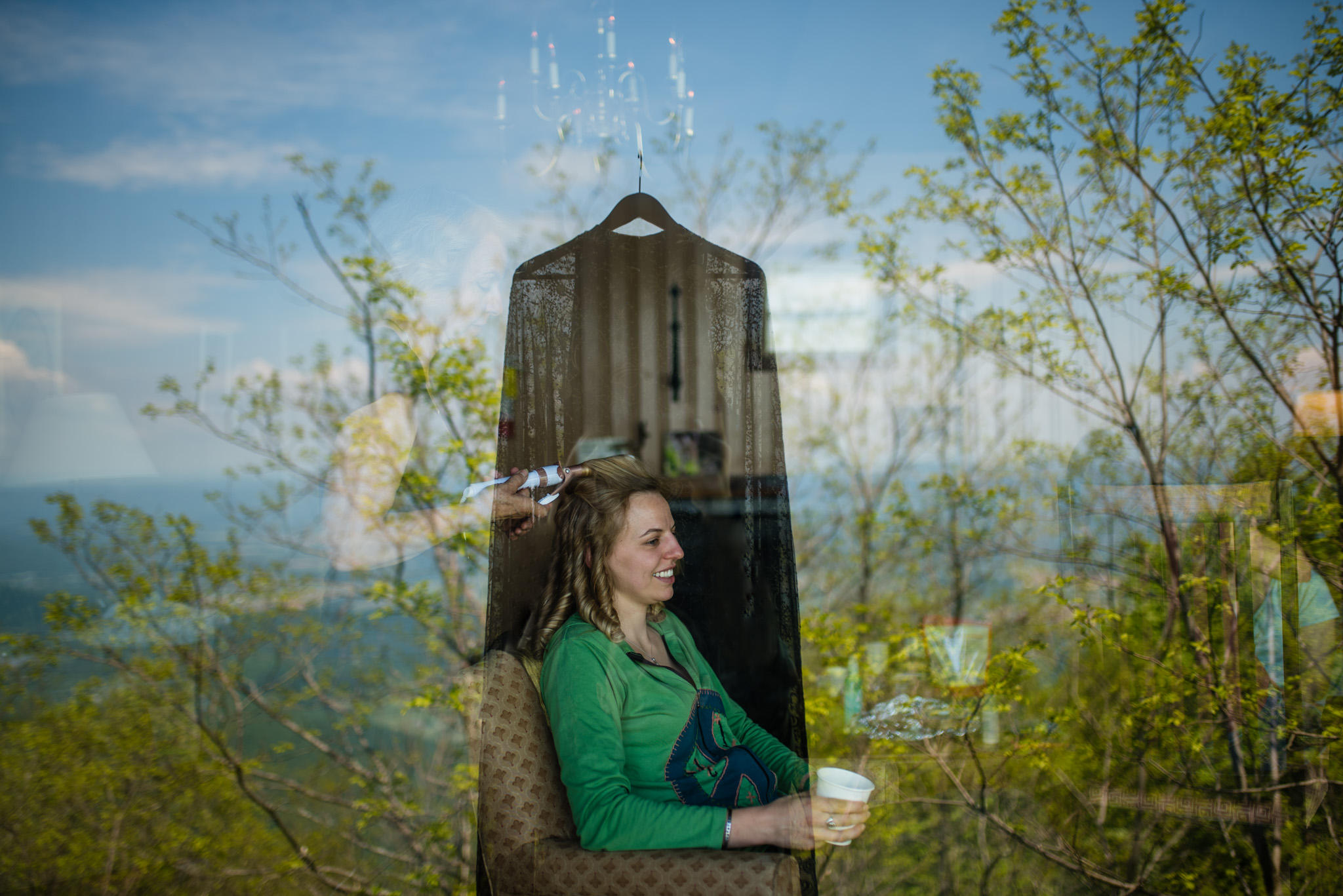 Reflection of a dress reveals bride through a window