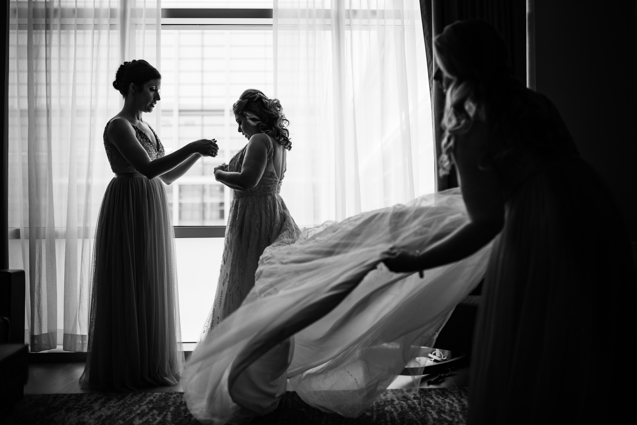 Bridesmaids helping the bride get ready