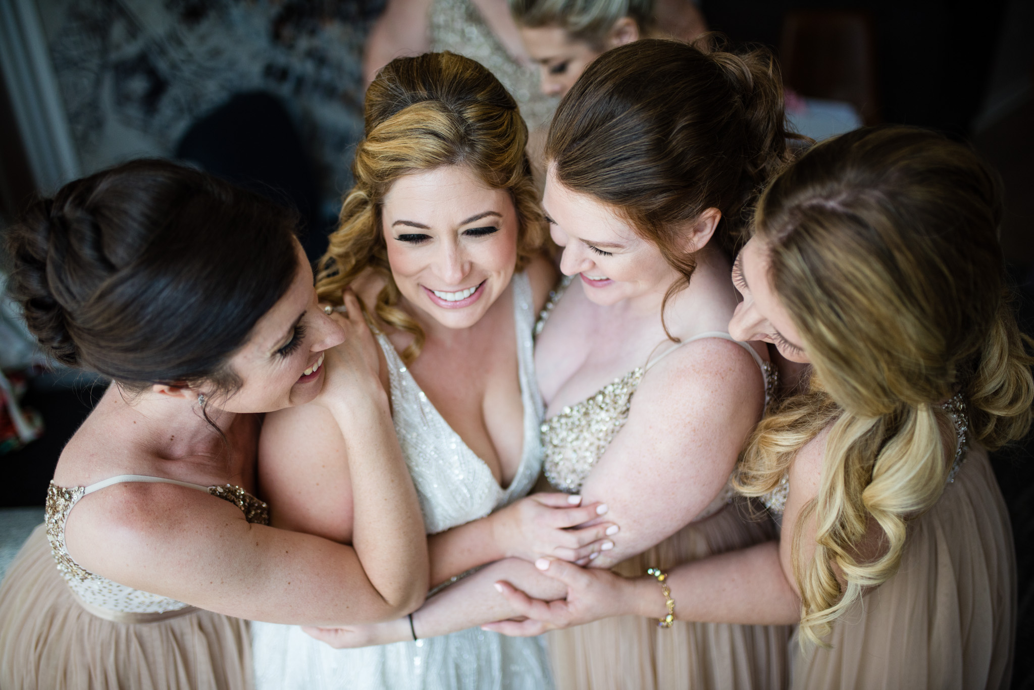 Bridesmaids coming together around the bride in joy