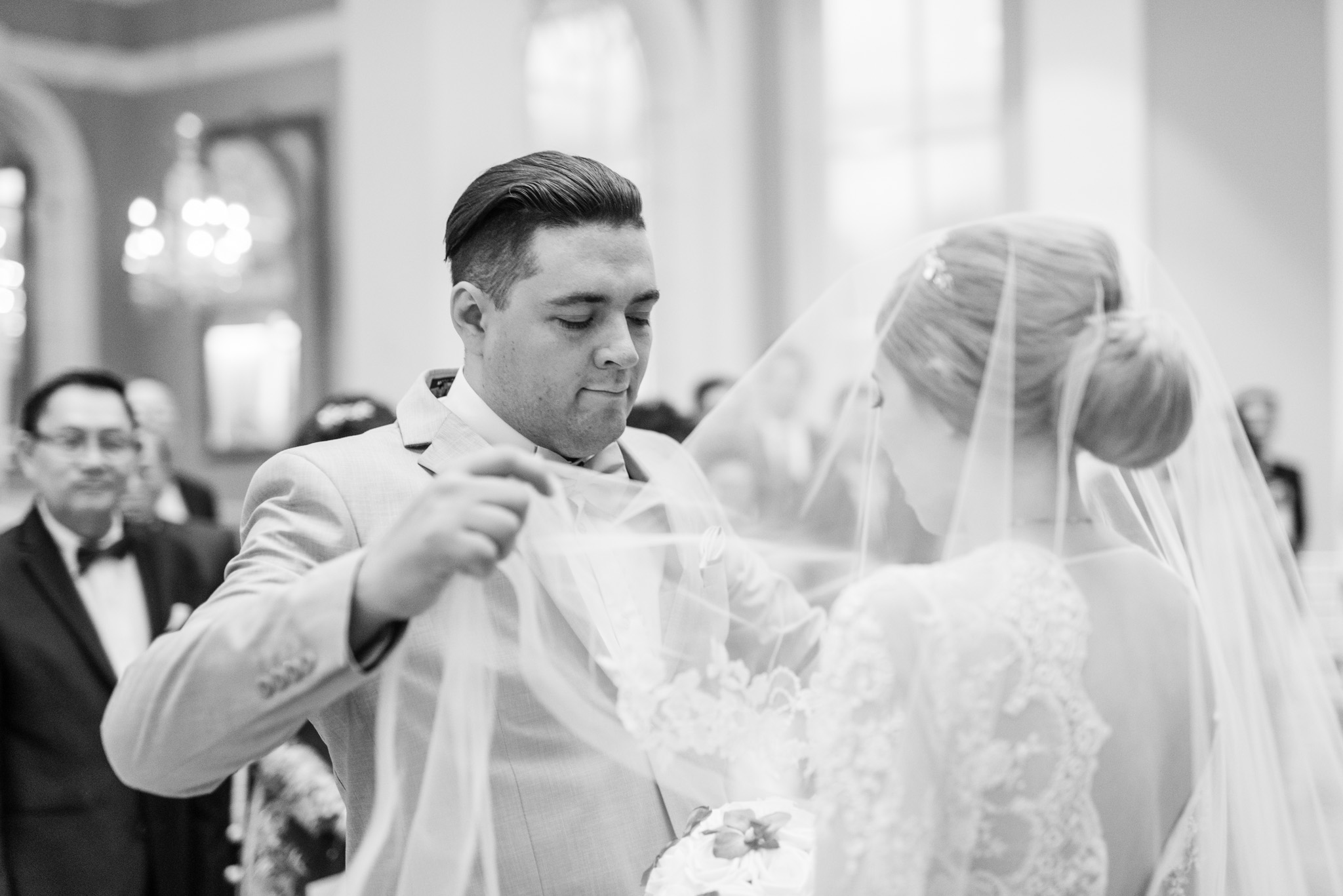 Brother lifting the wedding veil off of his sister